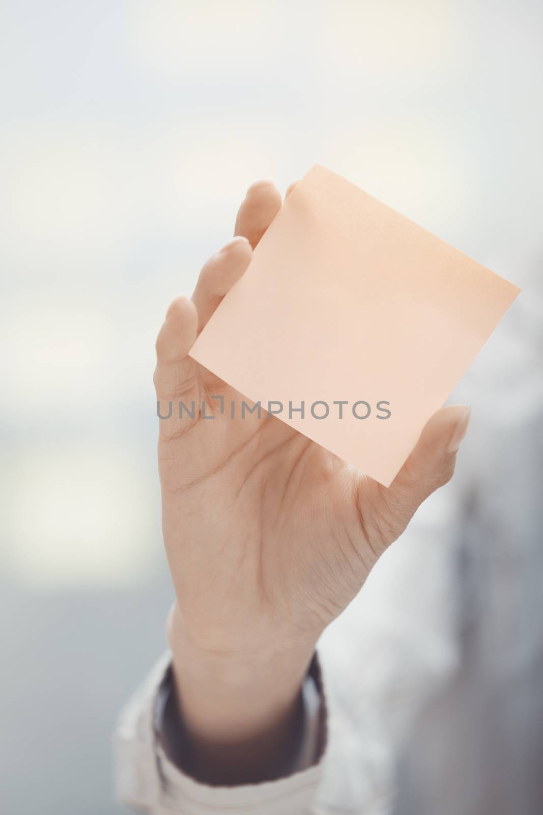Woman holding sticky note with empty space