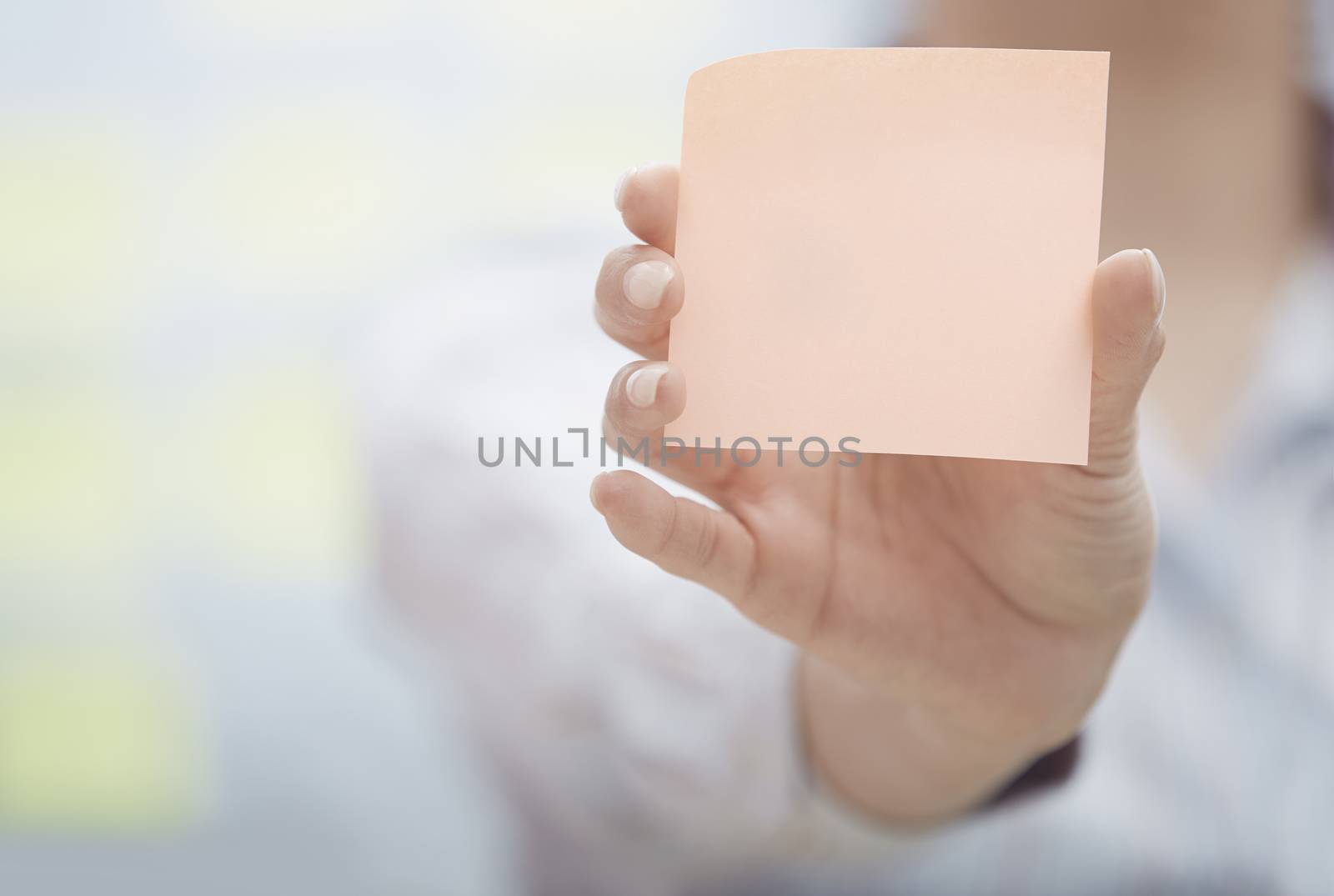 Hand of woman holding sticky note with empty space by Novic