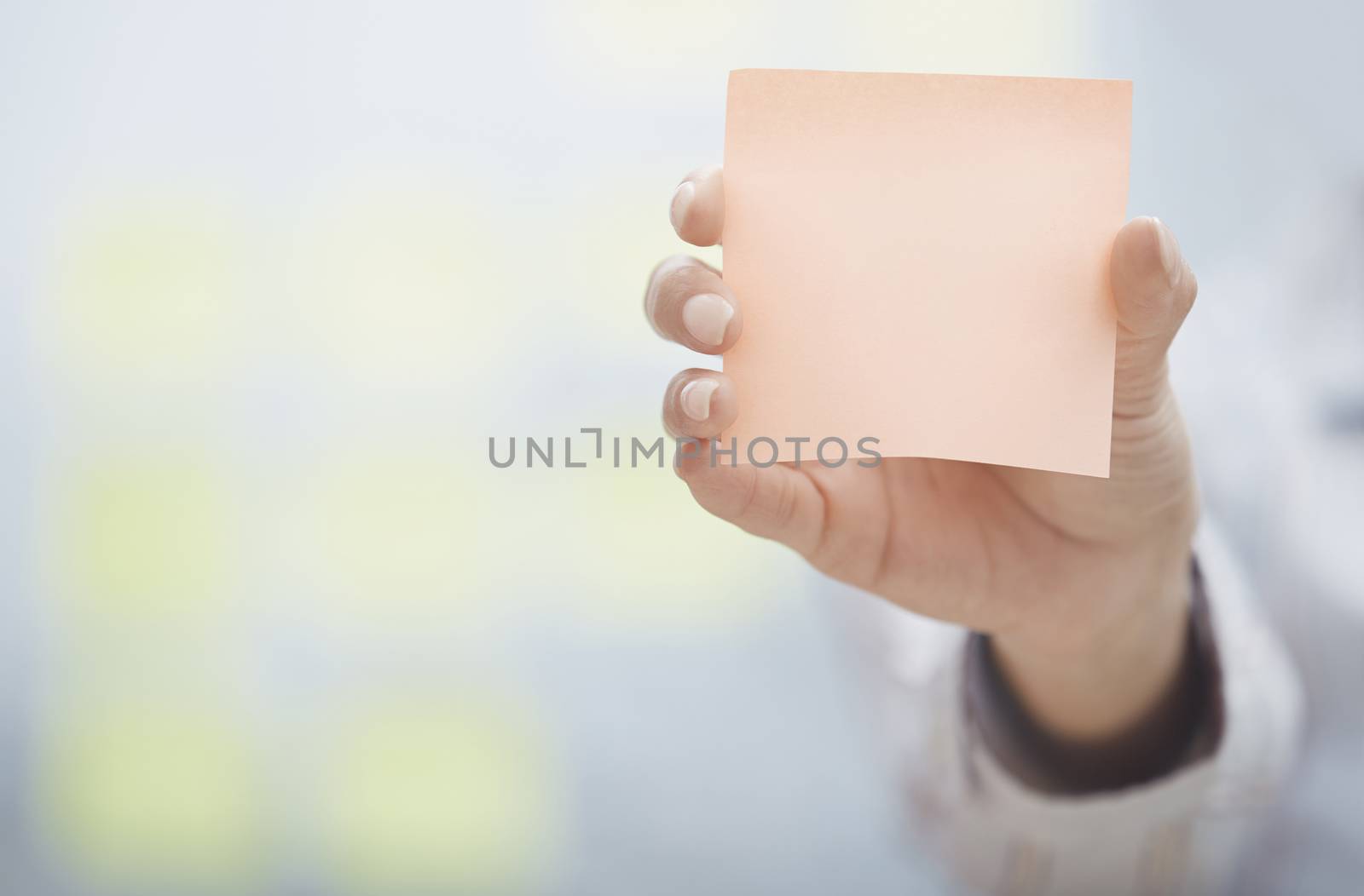 Hand of woman holding sticky note with empty space by Novic