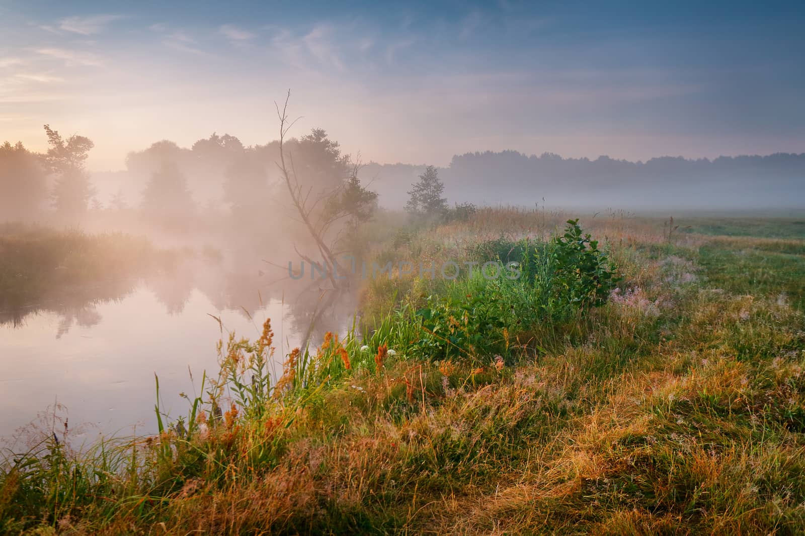 Summer misty sunrise on the river. Foggy river in the morning. Summer misty dawn. Foggy morning.