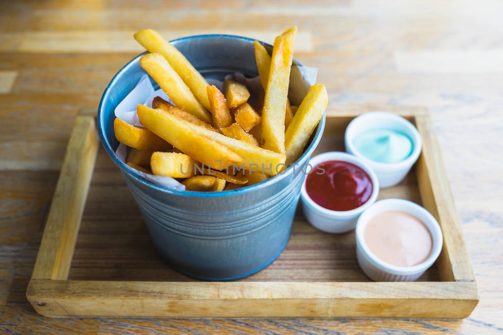 french fries in bucket with ketchup on wooden tray by luckyfim