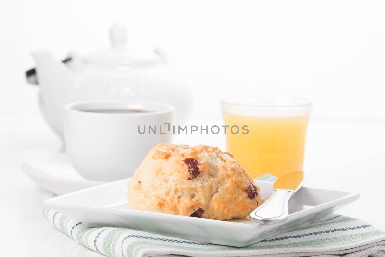 Fresh cranberry lemon scone served with coffee and juice.