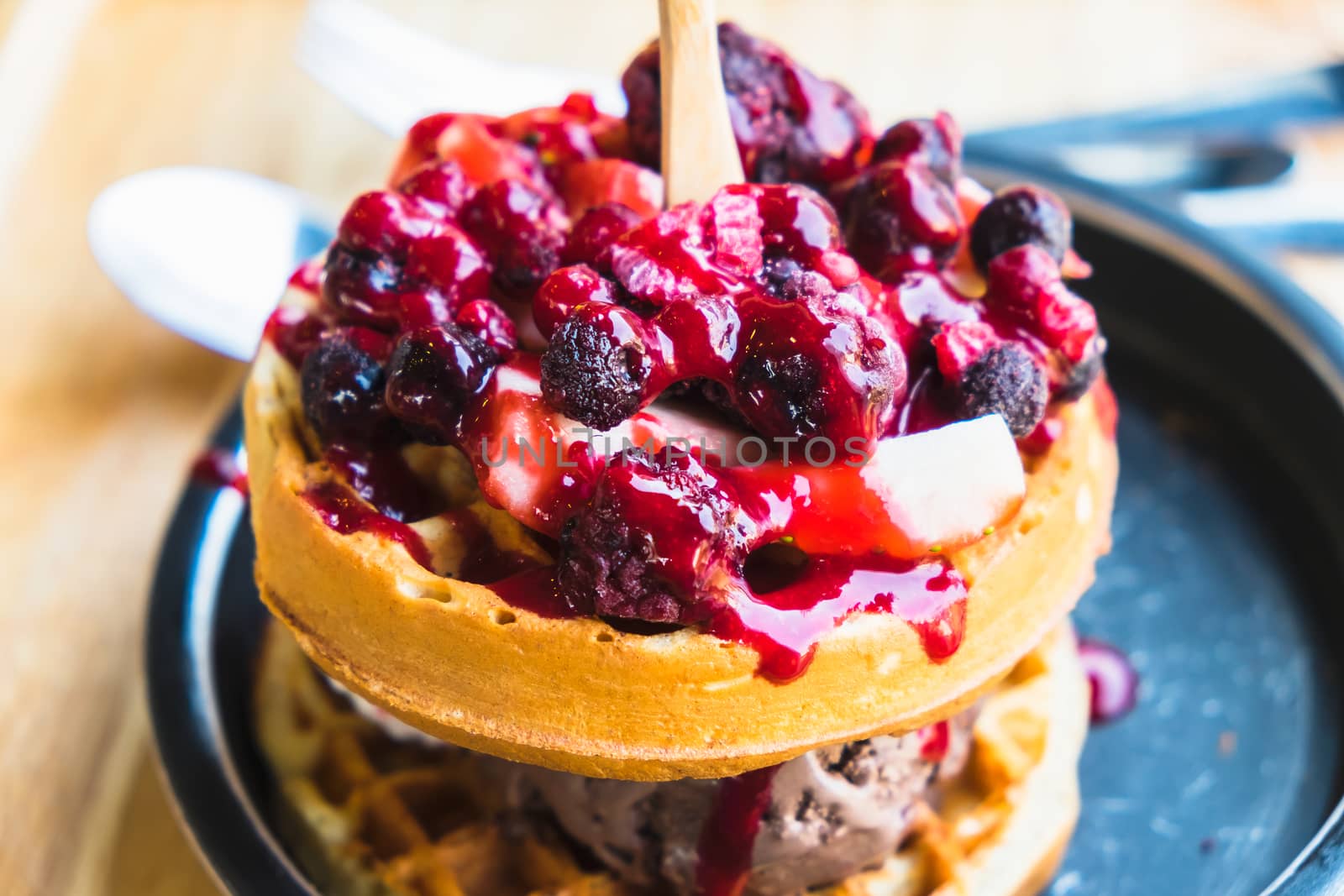 waffles and chocolate icecream with fresh berries on wooden tray by luckyfim