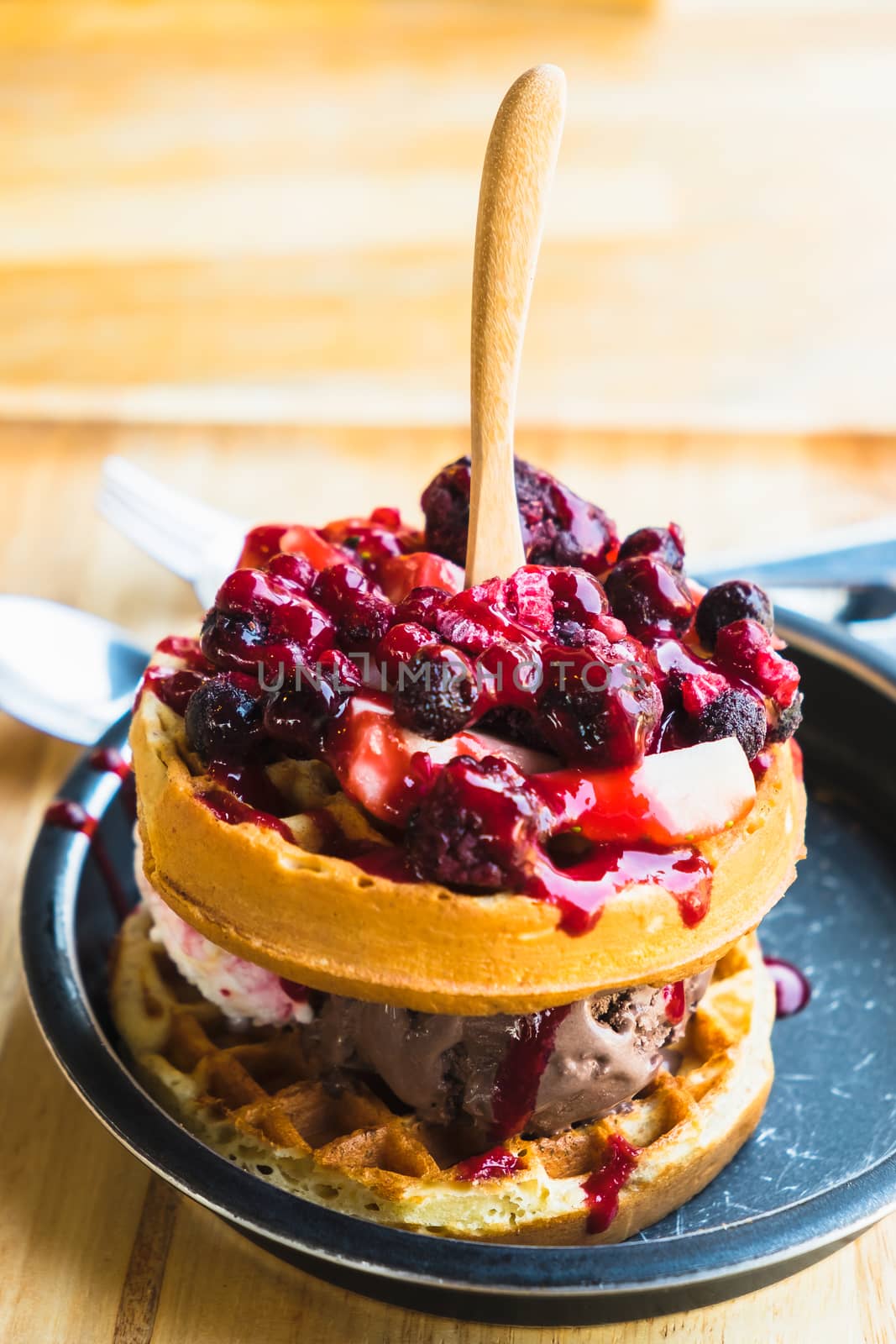 waffles and chocolate icecream with fresh berries on wooden tray