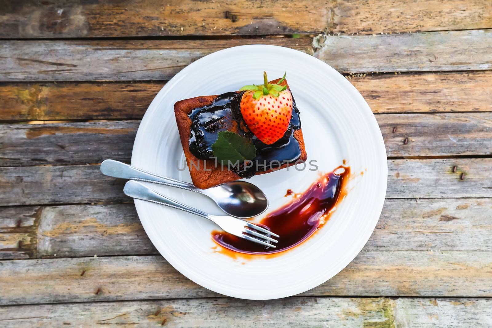chocolate cake on white dish with strawberry by luckyfim