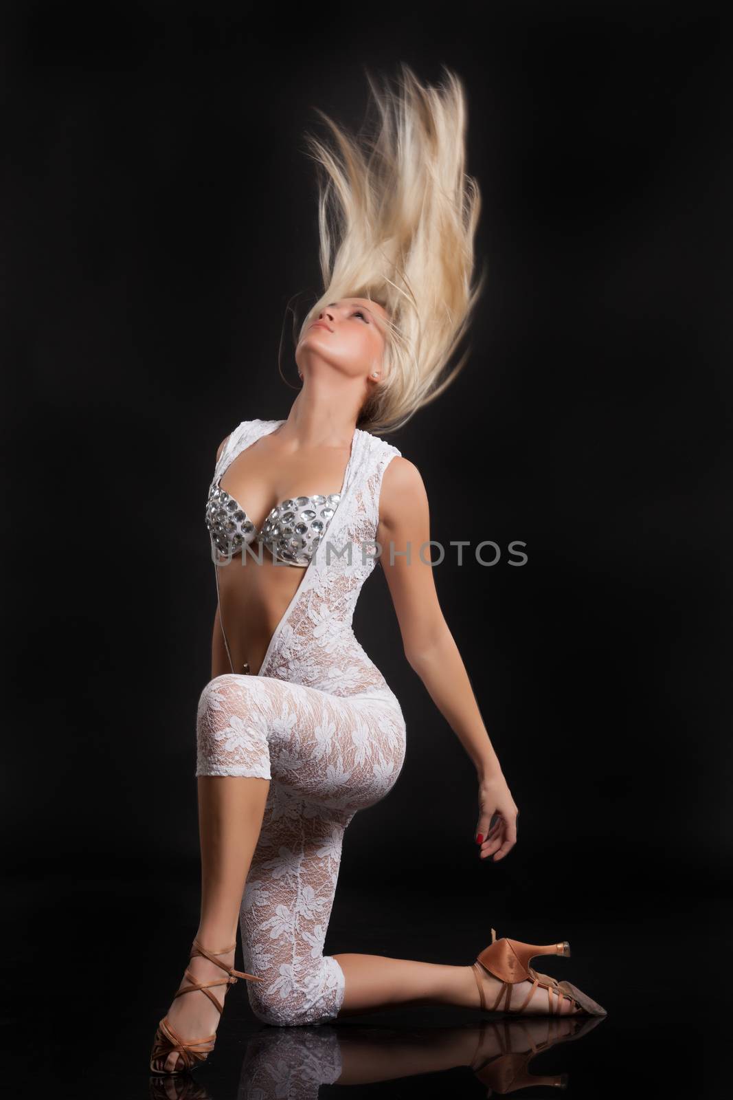 Young woman with flying hair on a black studio background