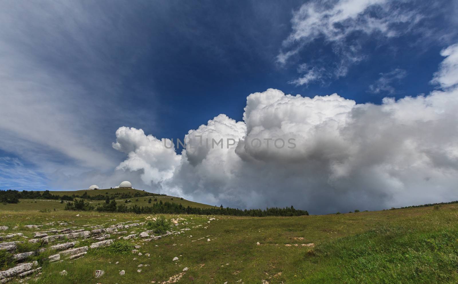 Weather station in the mountains, on a background of blue and cloudy sky