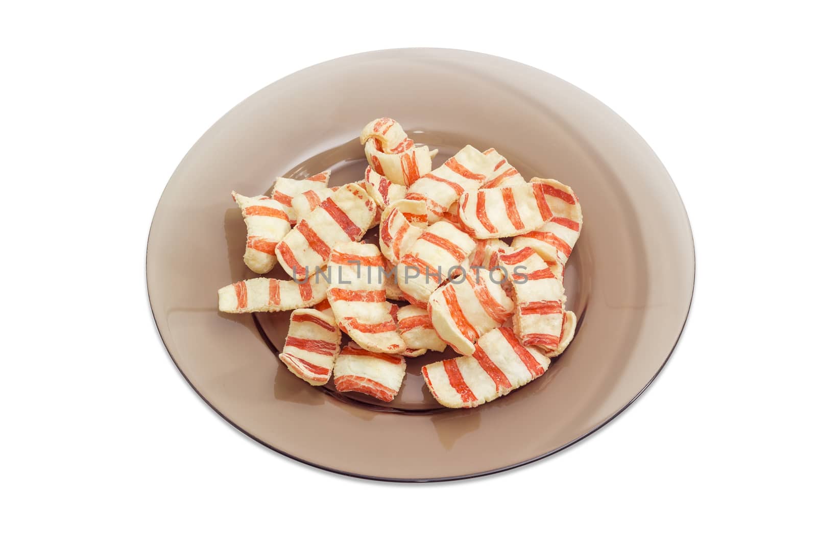 Potato chips with appearance and taste of a bacon on dark glass dish on a light background
