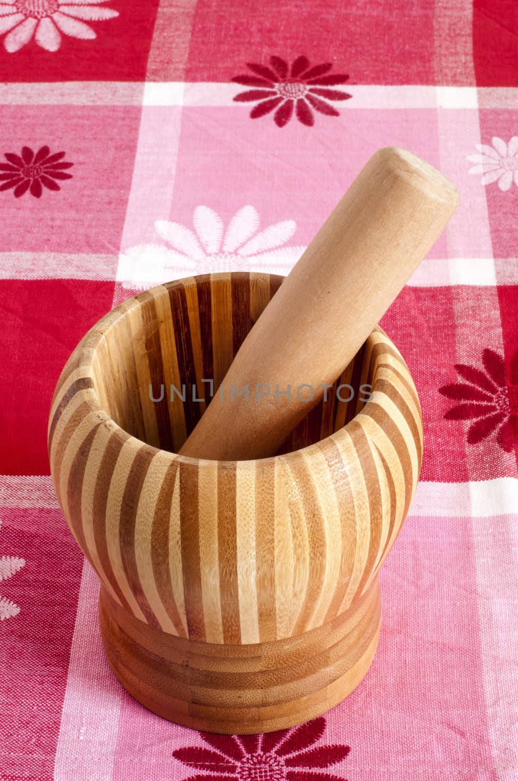 a wooden mortar over a patterned fabric