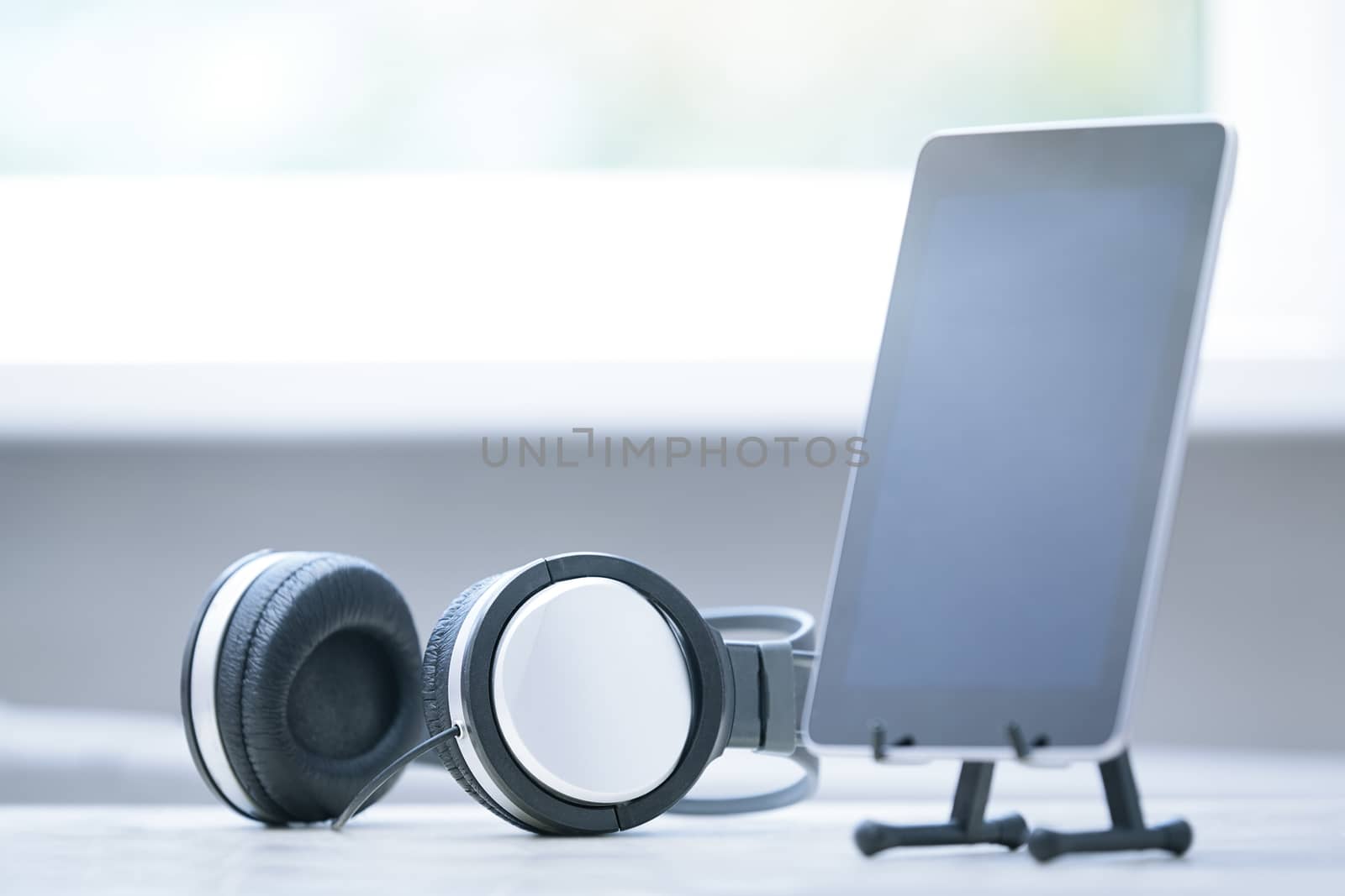 Headphones and digital tablet at office by Novic
