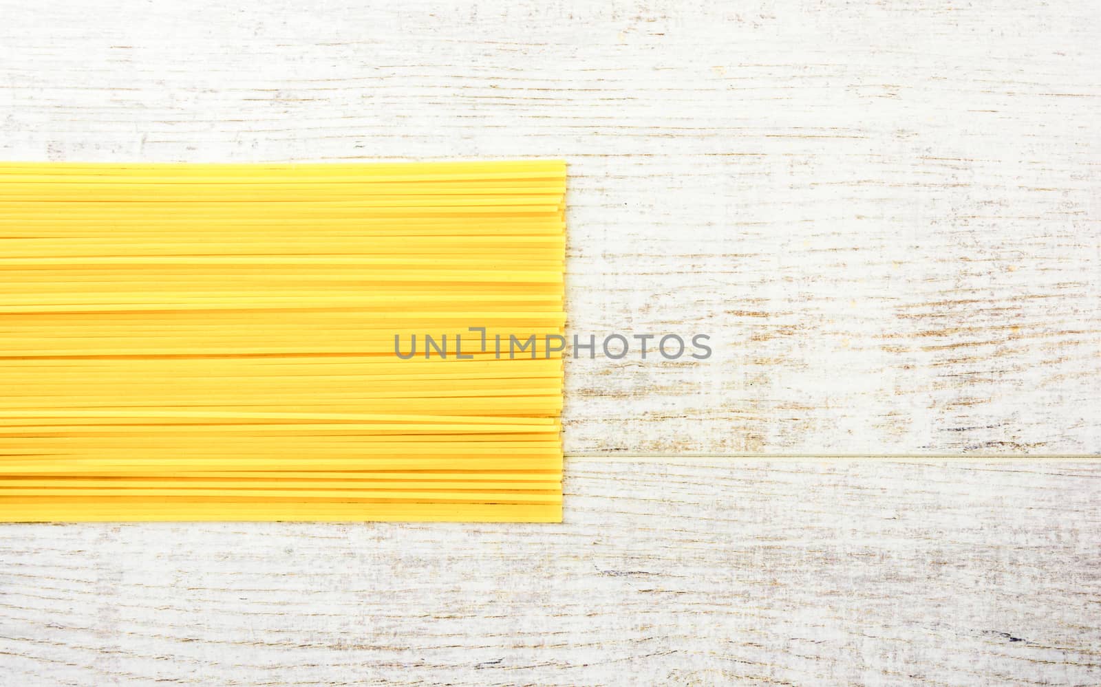 Italian raw pasta on a white surface. Top view, copy space.