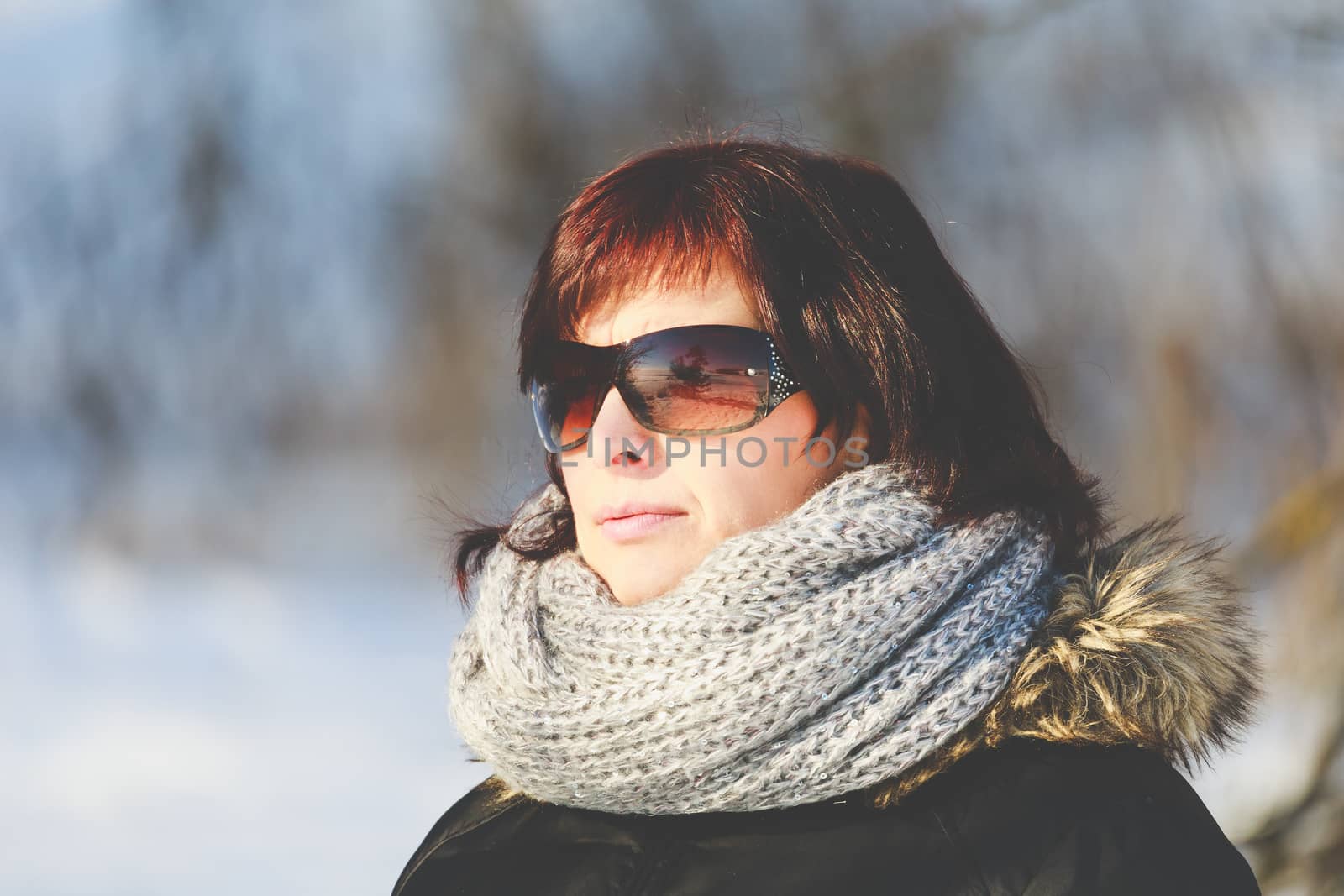 portrait of happy smiling middle age woman without makeup in winter time with sunglasses
