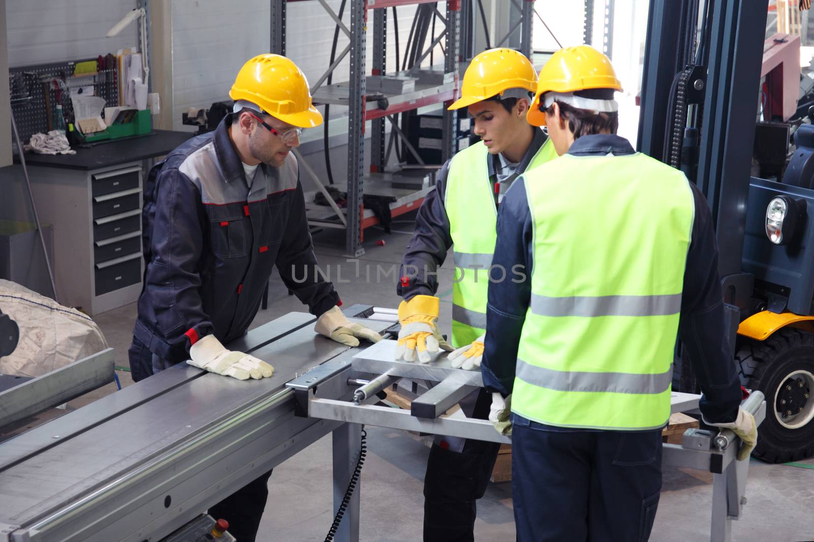 Workers in uniform in CNC machine shop with lathes