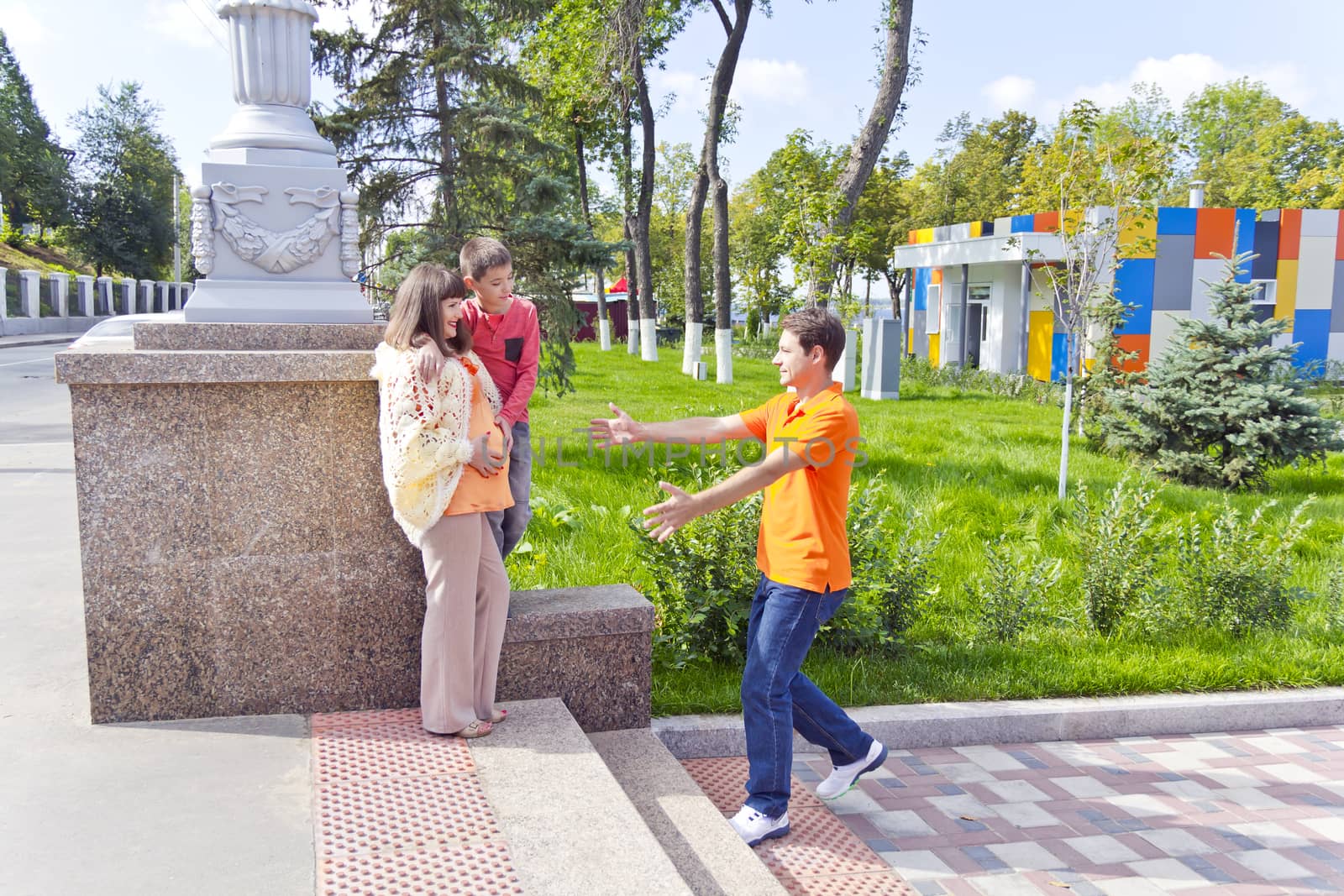 Meeting pregnant mother and son with father in summer embankment