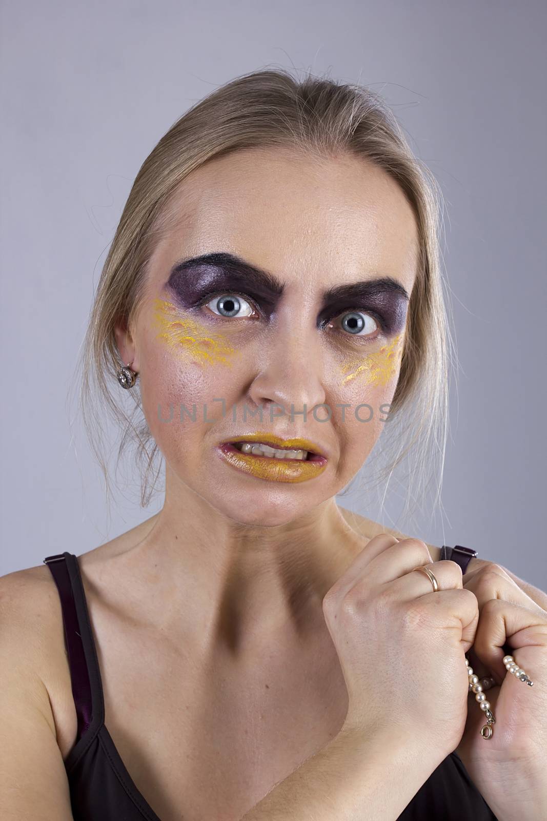 Portrait of a young greedy woman on a gray background. Seven Deadly Sins