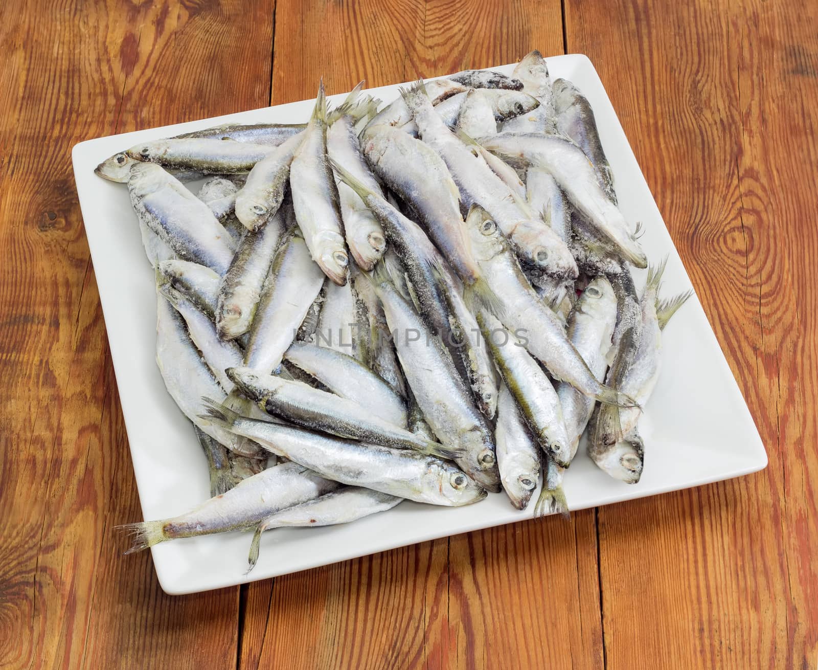 Frozen baltic herring on a square white dish by anmbph