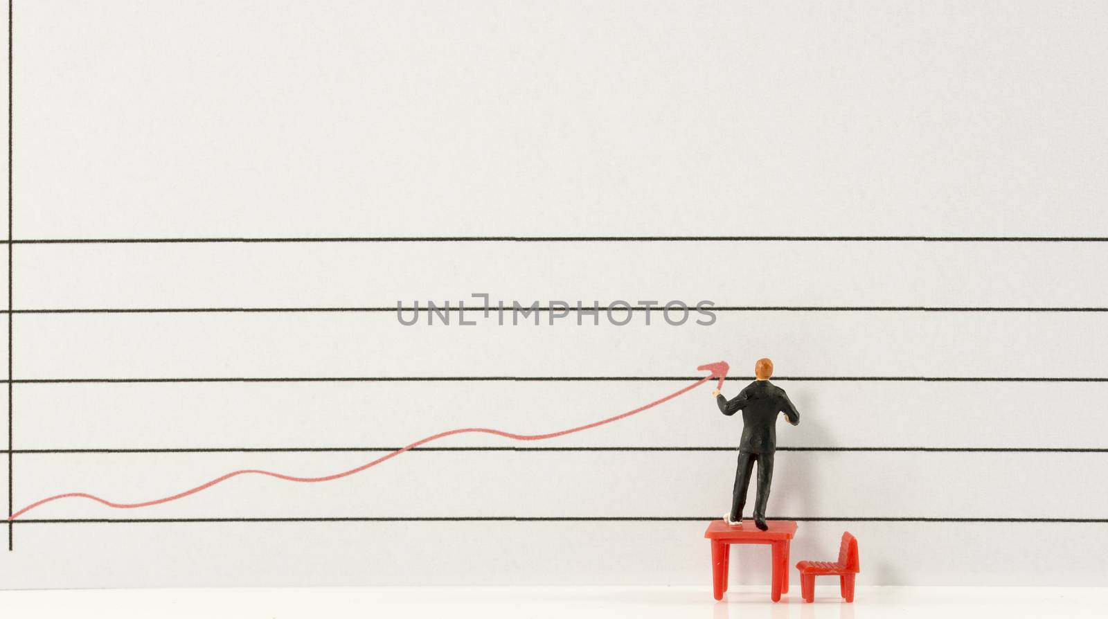miniature man showing increase and grow of marketing by red graphic line