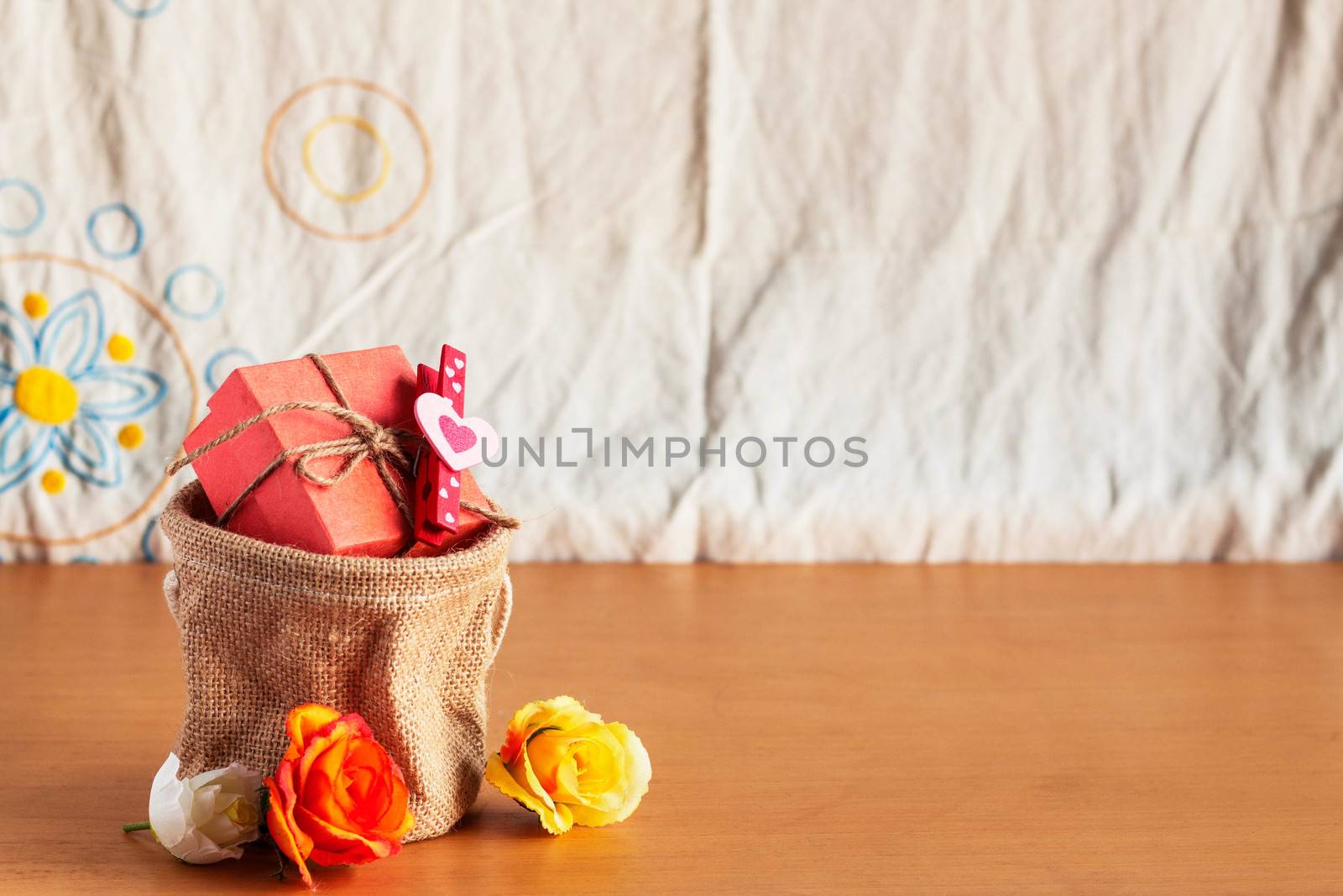 Gift bags and roses on a wooden floor.