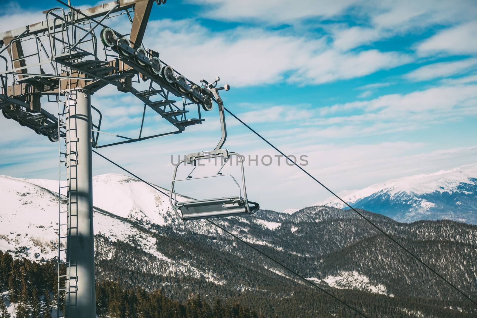 Ropeway and chair lifts driving at ski resort on beautiful snowing day. Landscape.