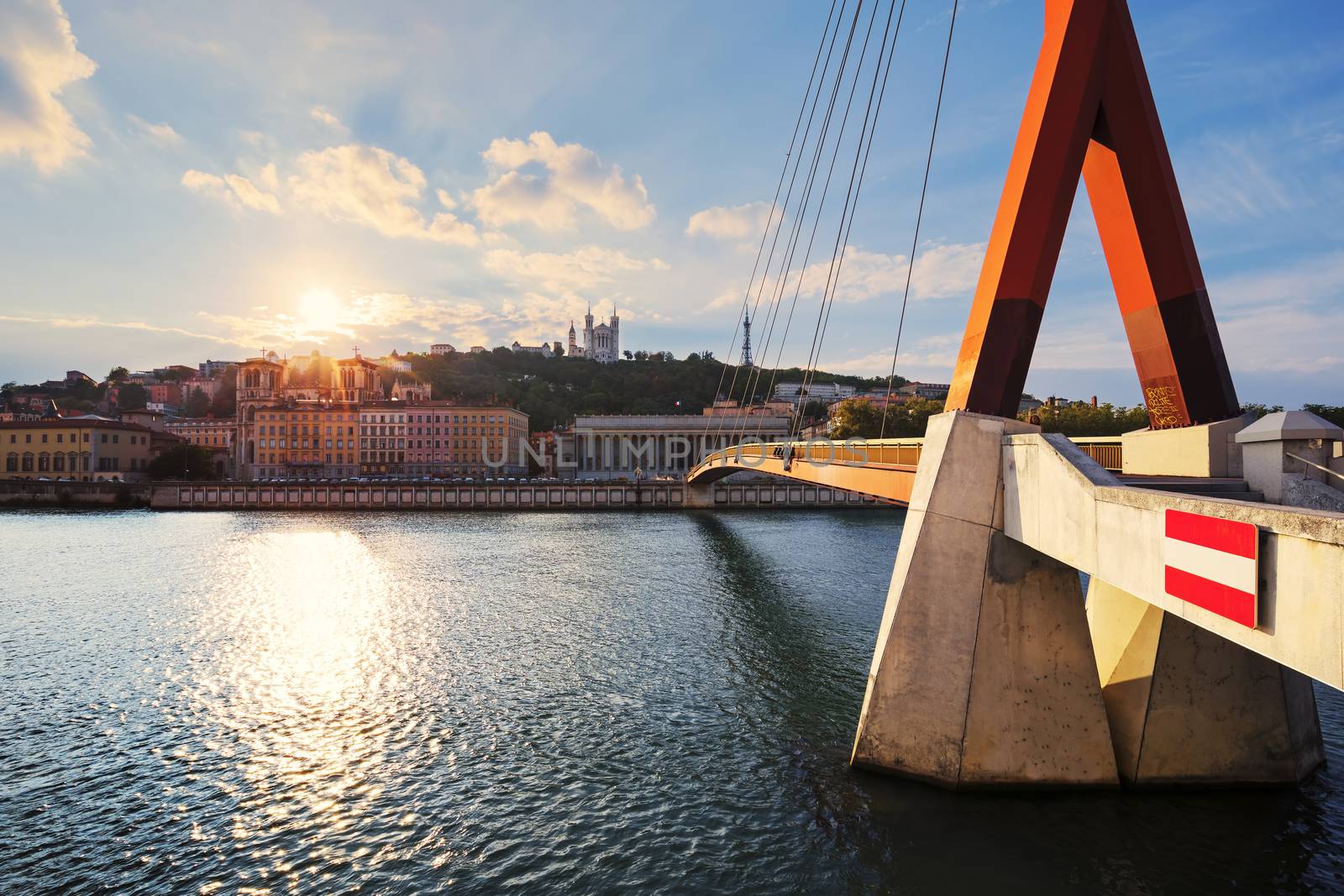 Cloudy sunset over Vieux Lyon and Fourviere Basilica seen from the riverbank of the Saone, Lyon.