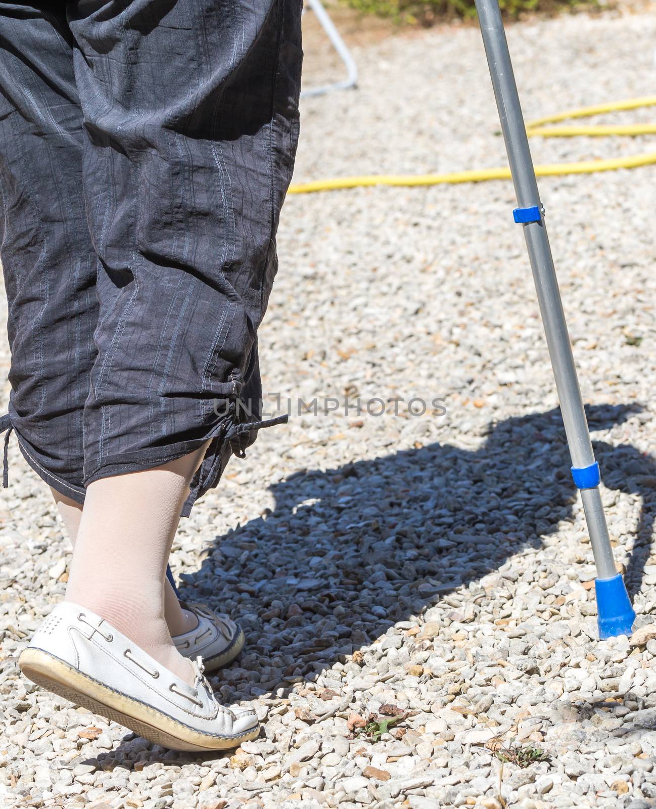 Closeup of Senior woman walking with crutches in her garden