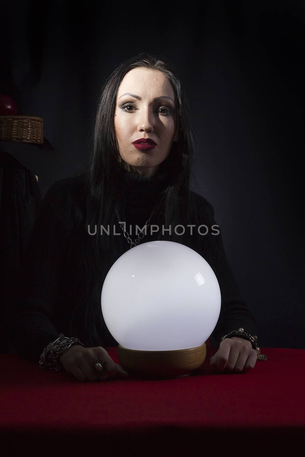 Fortune teller with a magic ball on a black background