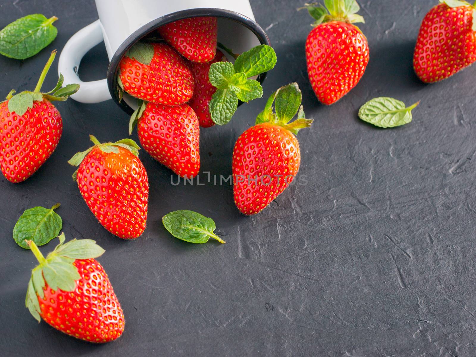 Fresh red strawberries on dark background. Strawberry in rustic cup on oriental black background. Top view or flat lay. Copyspace