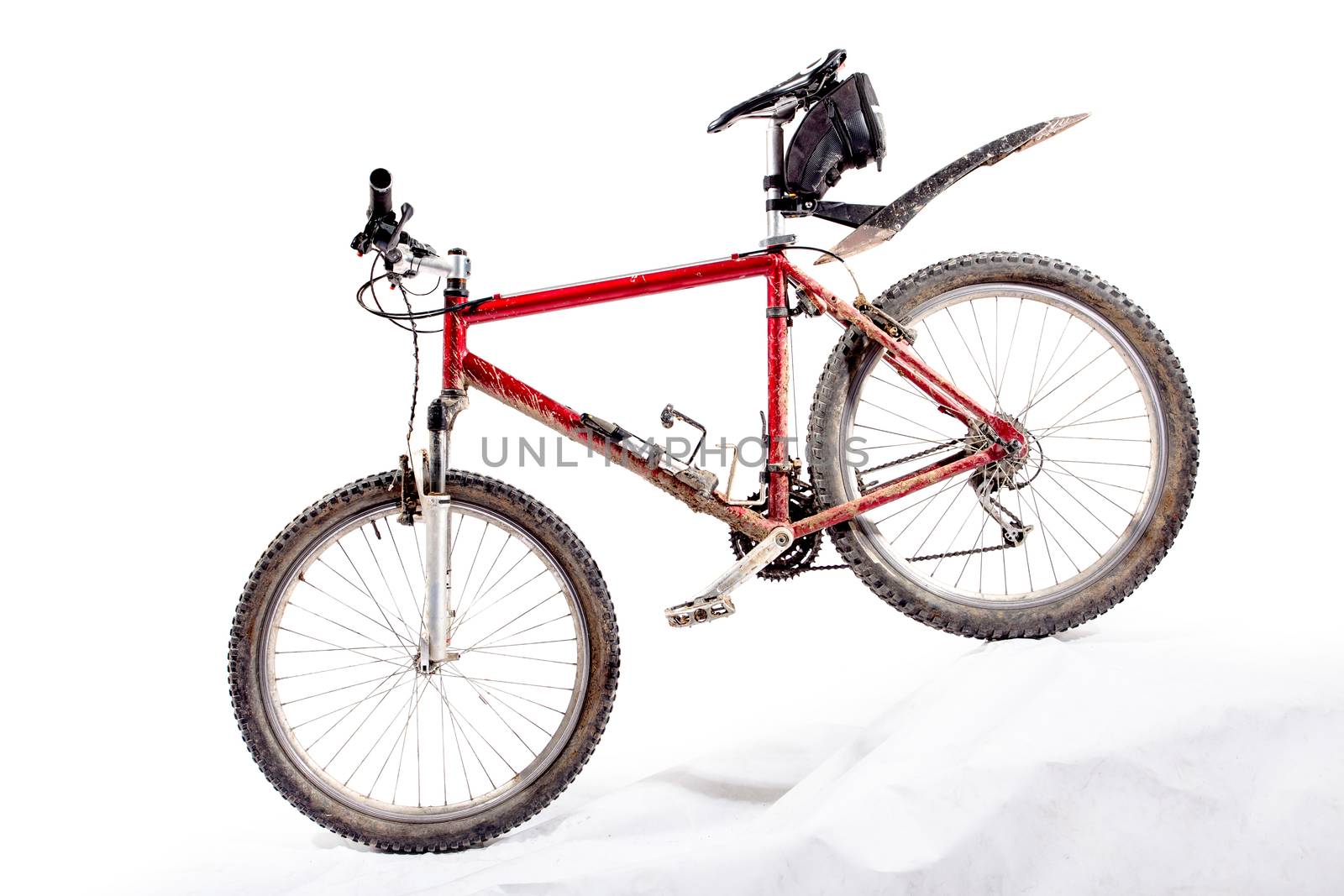 red hardtail mountain bike in a very dirty condition