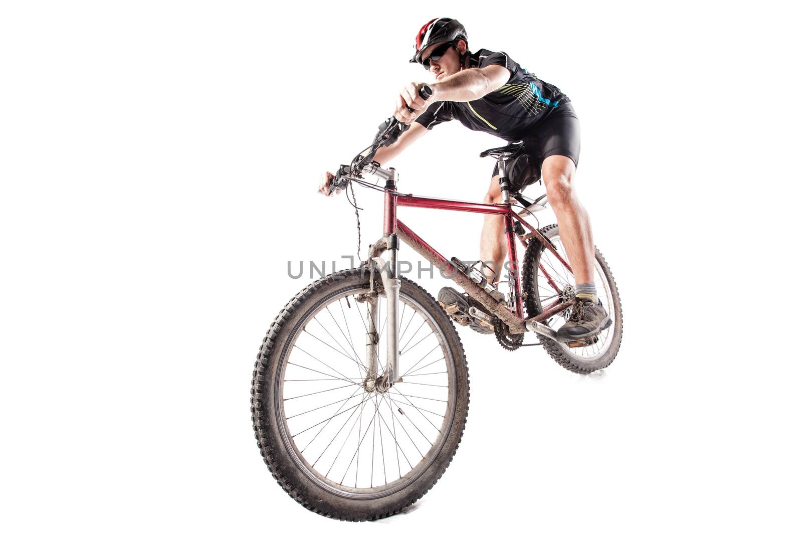 Male bicyclist riding a very dirty mountain bike downhill style