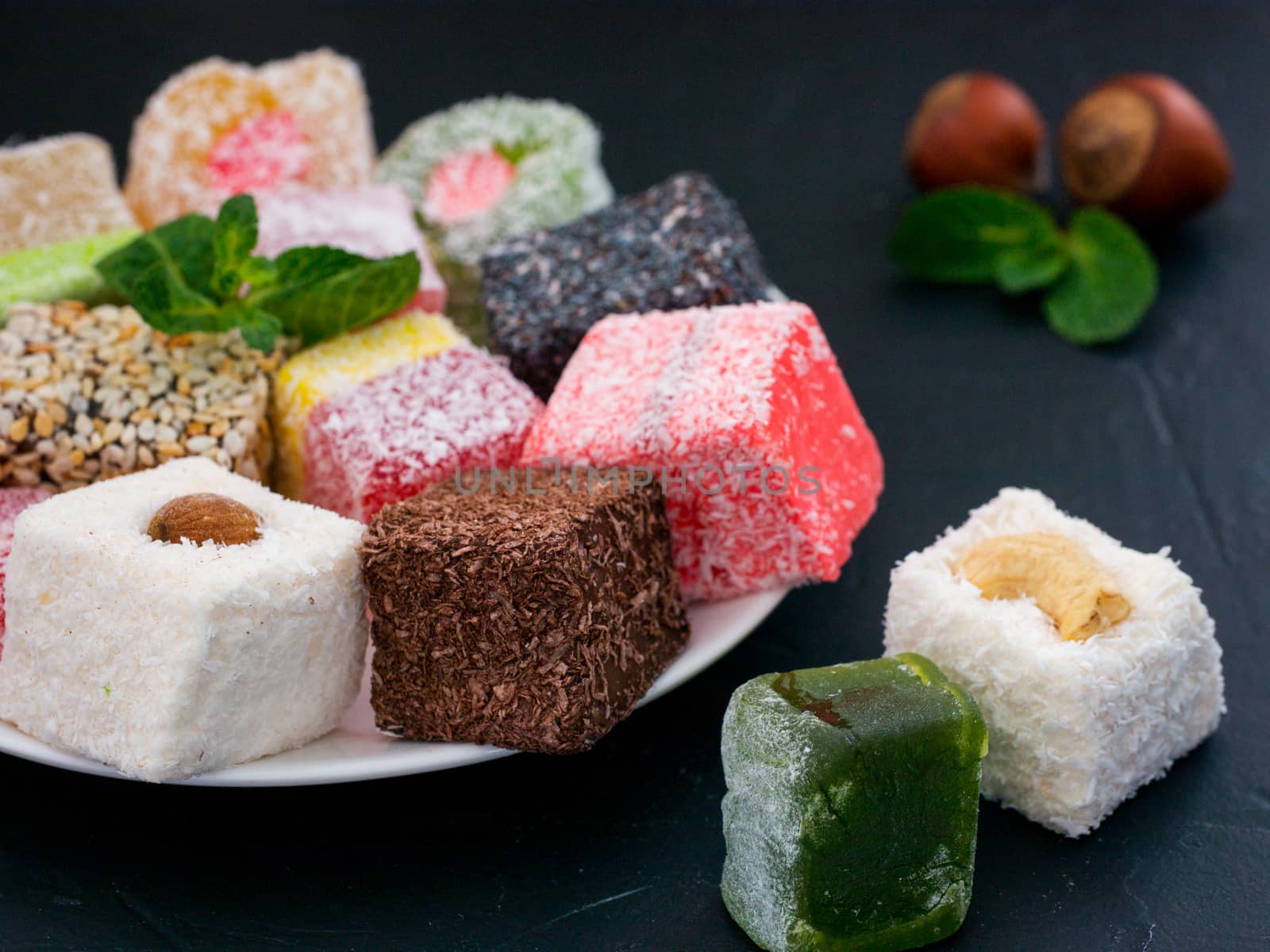 Turkish delight on black rustic background. Turkish deligh set. Assorted traditional turkish delight on oriental dark background