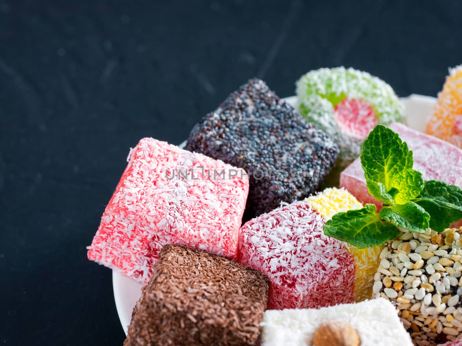 Turkish delight on black rustic background. Turkish deligh set. Assorted traditional turkish delight on oriental dark background