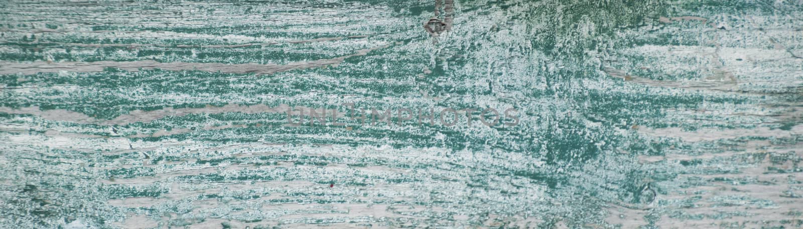 Worn white weathered painted board with green underneath