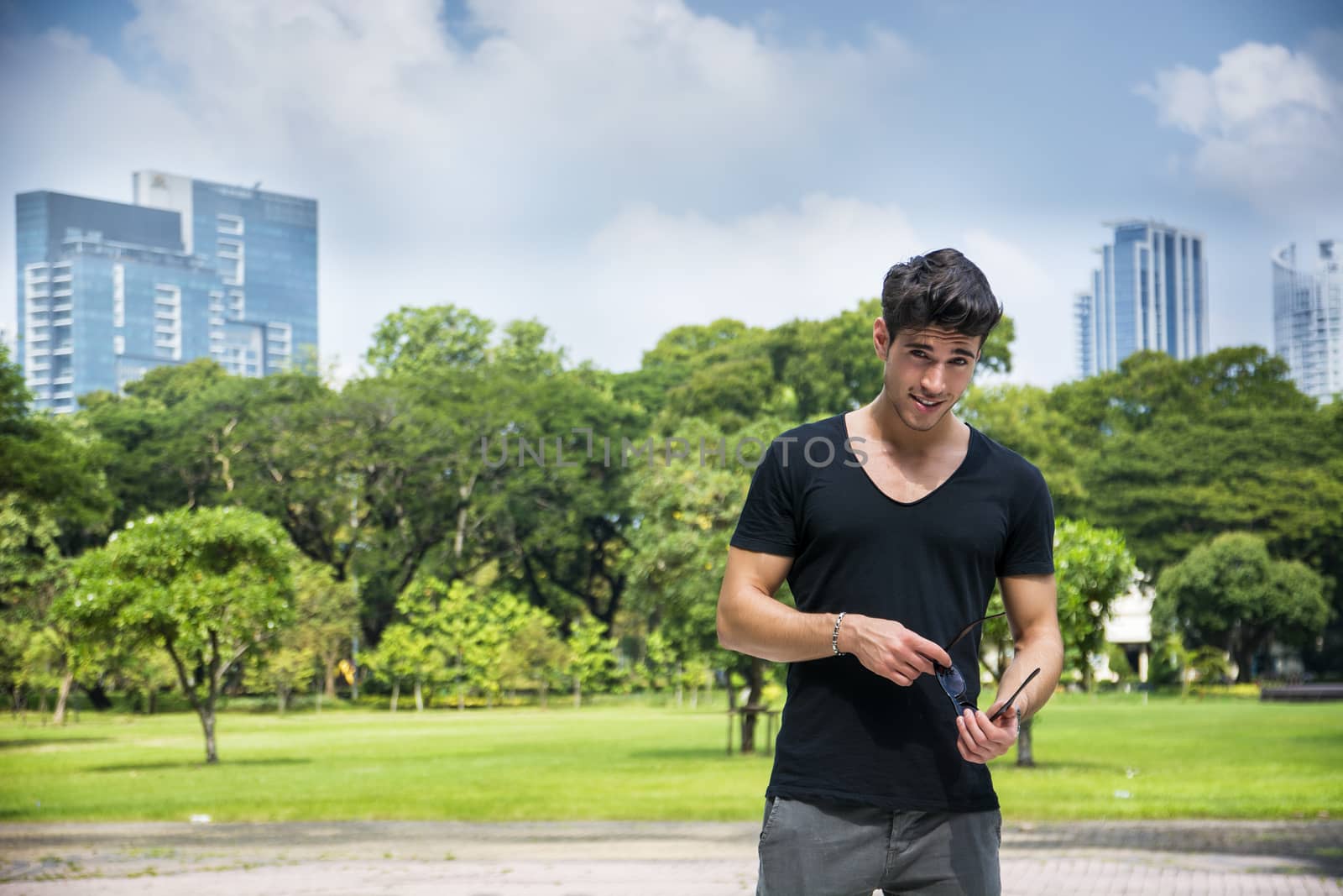 Handsome young man outdoors in city park by artofphoto