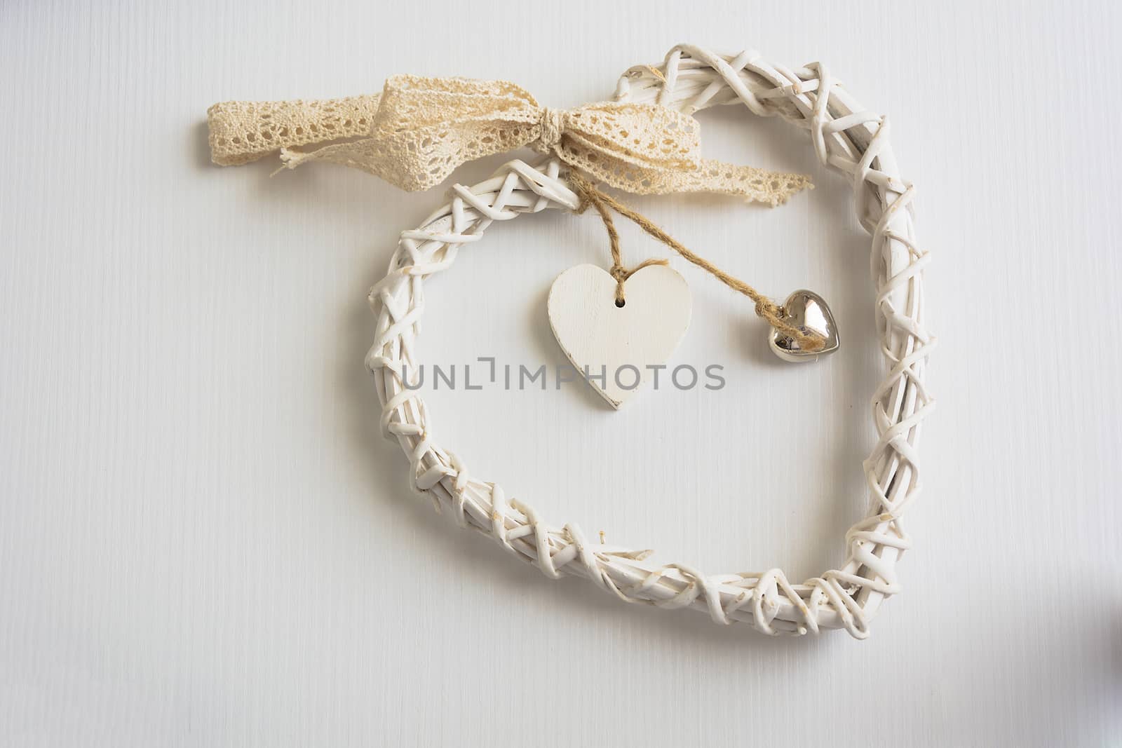 Two wooden hearts placed nicely on a white wood background