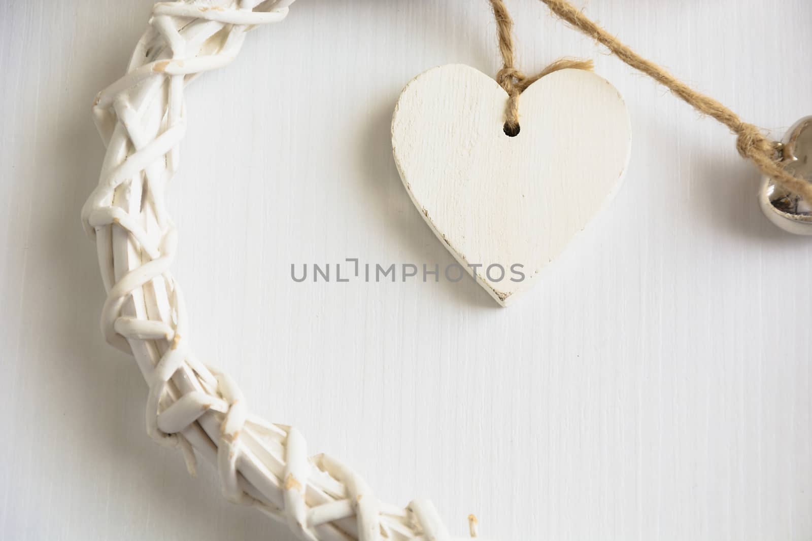 Two wooden hearts placed nicely on a white wood background