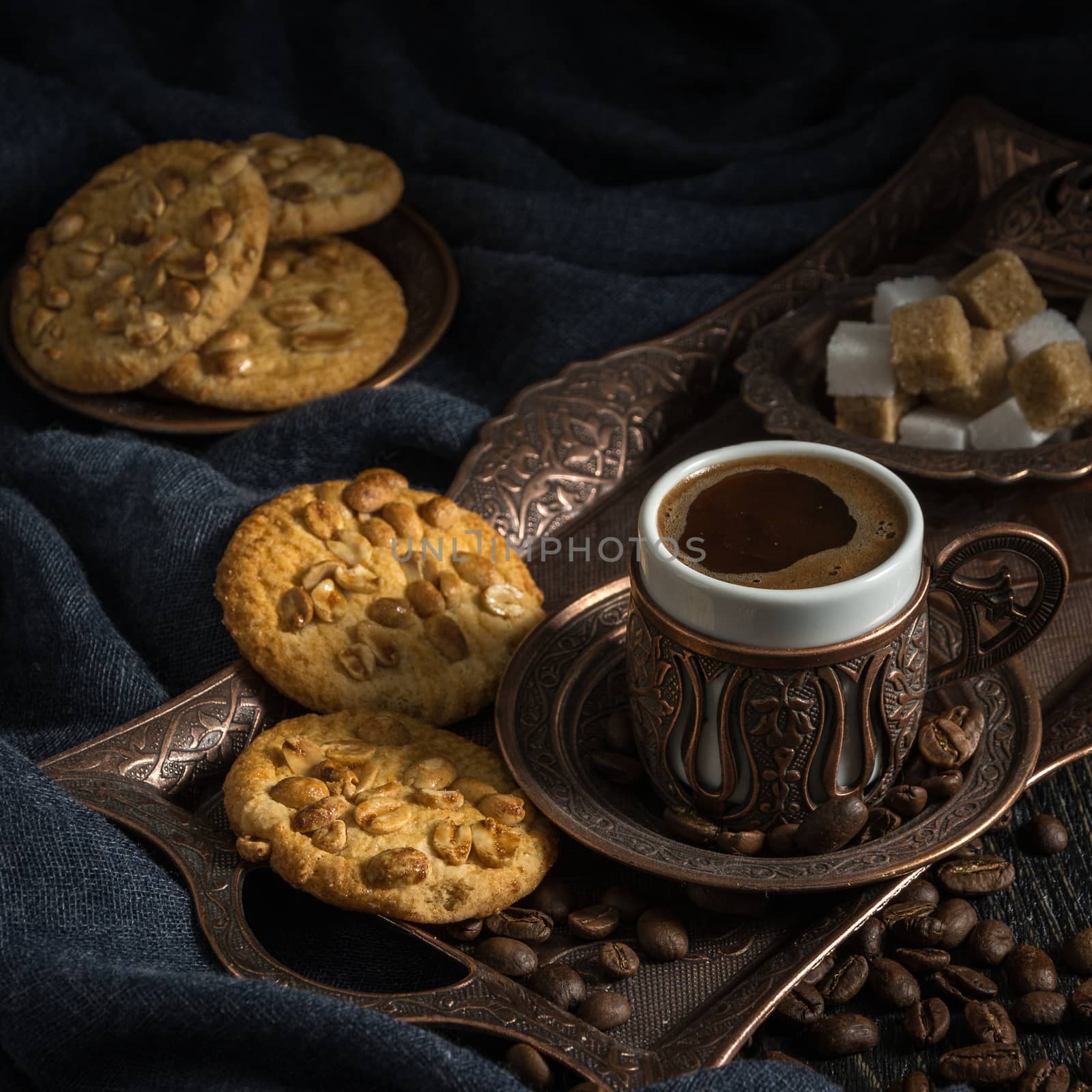 black coffee in beautiful east cup with cookies against a dark background in a dark key