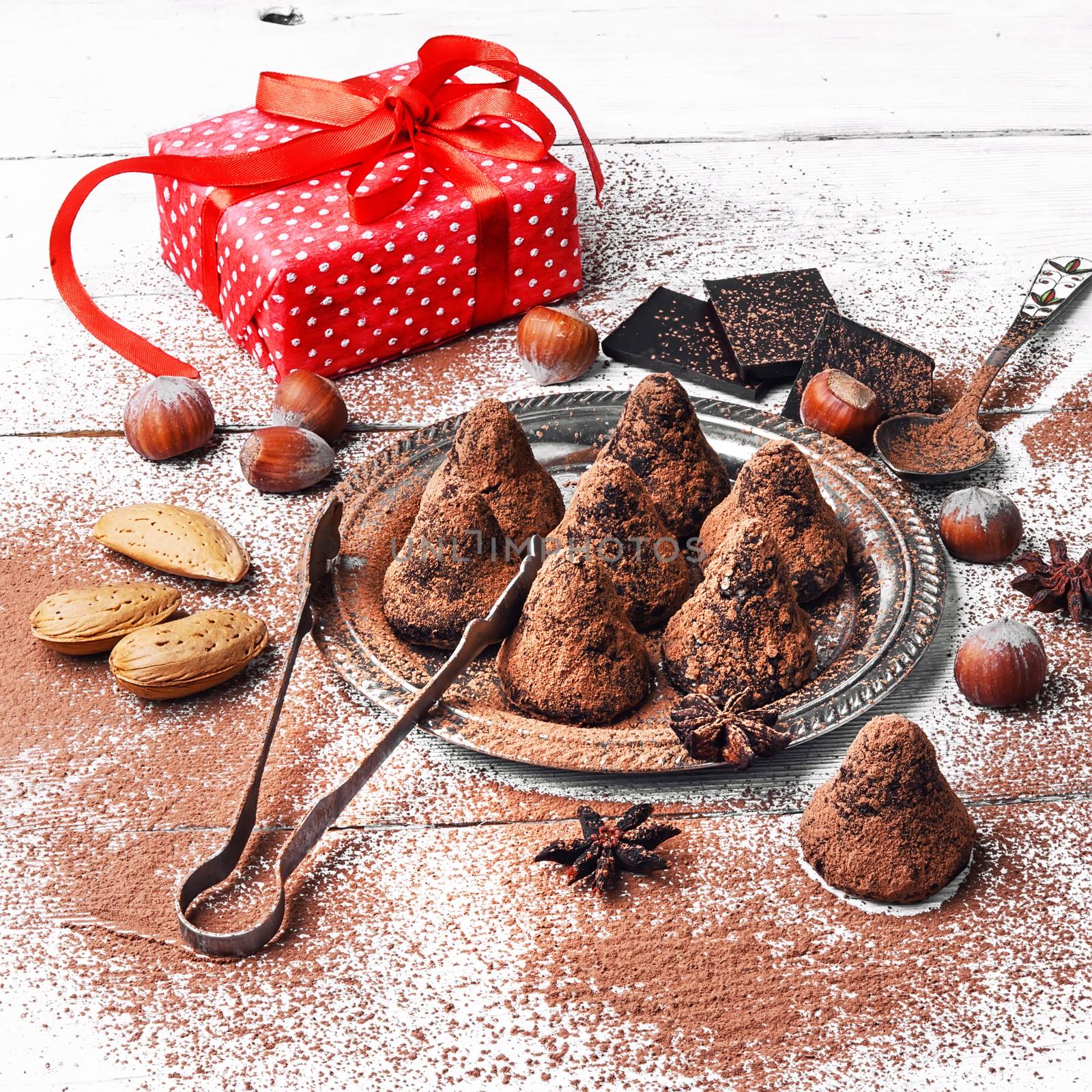 Chocolate truffles with cocoa and nuts and red box with gift