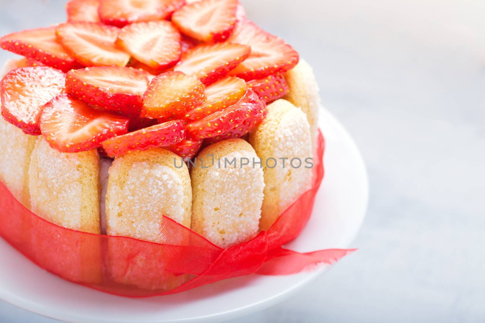 Yogurt strawberry cake with savoiardi biscuits on a plate