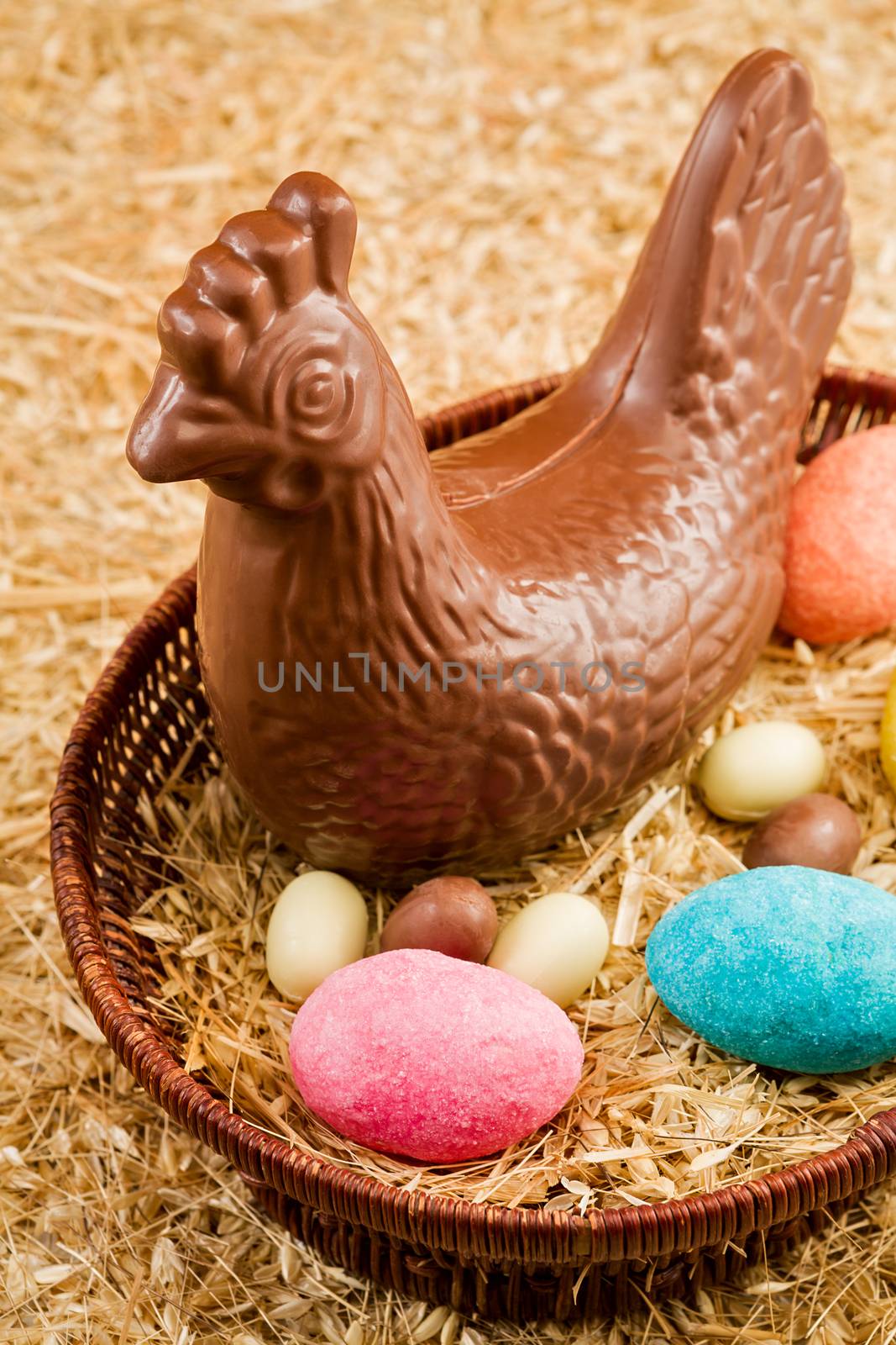 Easter chocolate hen and eggs in a basket over the straw