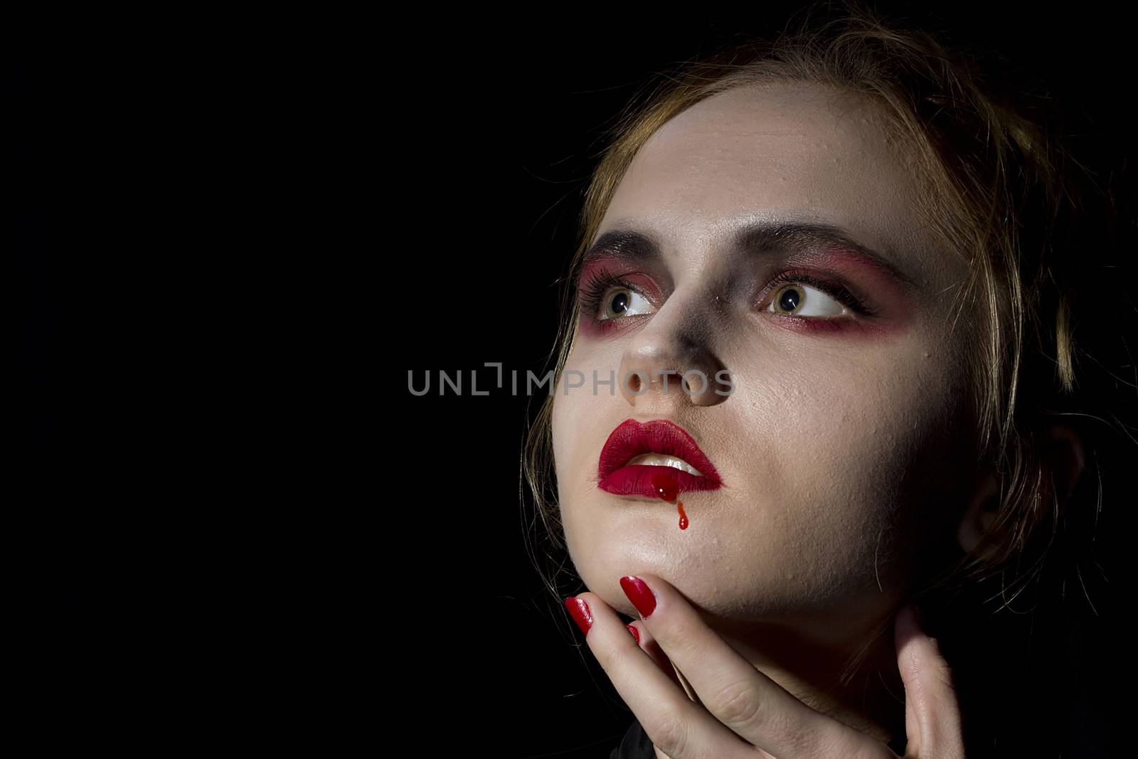 Young girl vampire on a black background