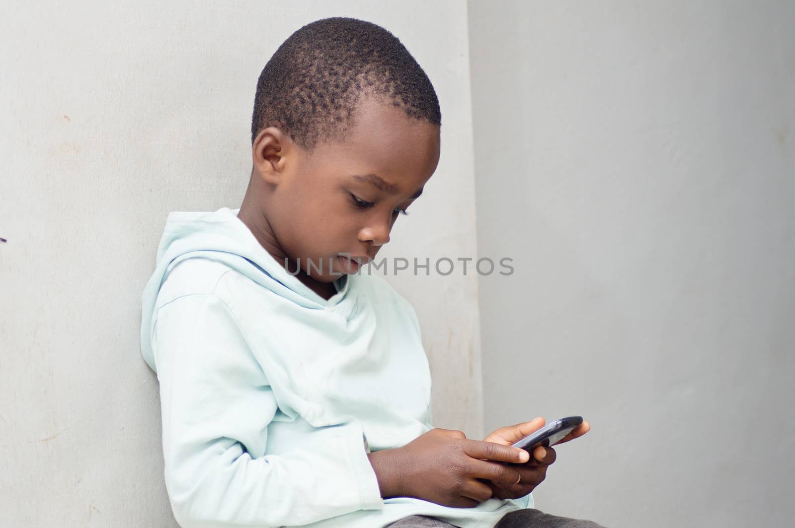 This child is playing a game  in the mobile phone.