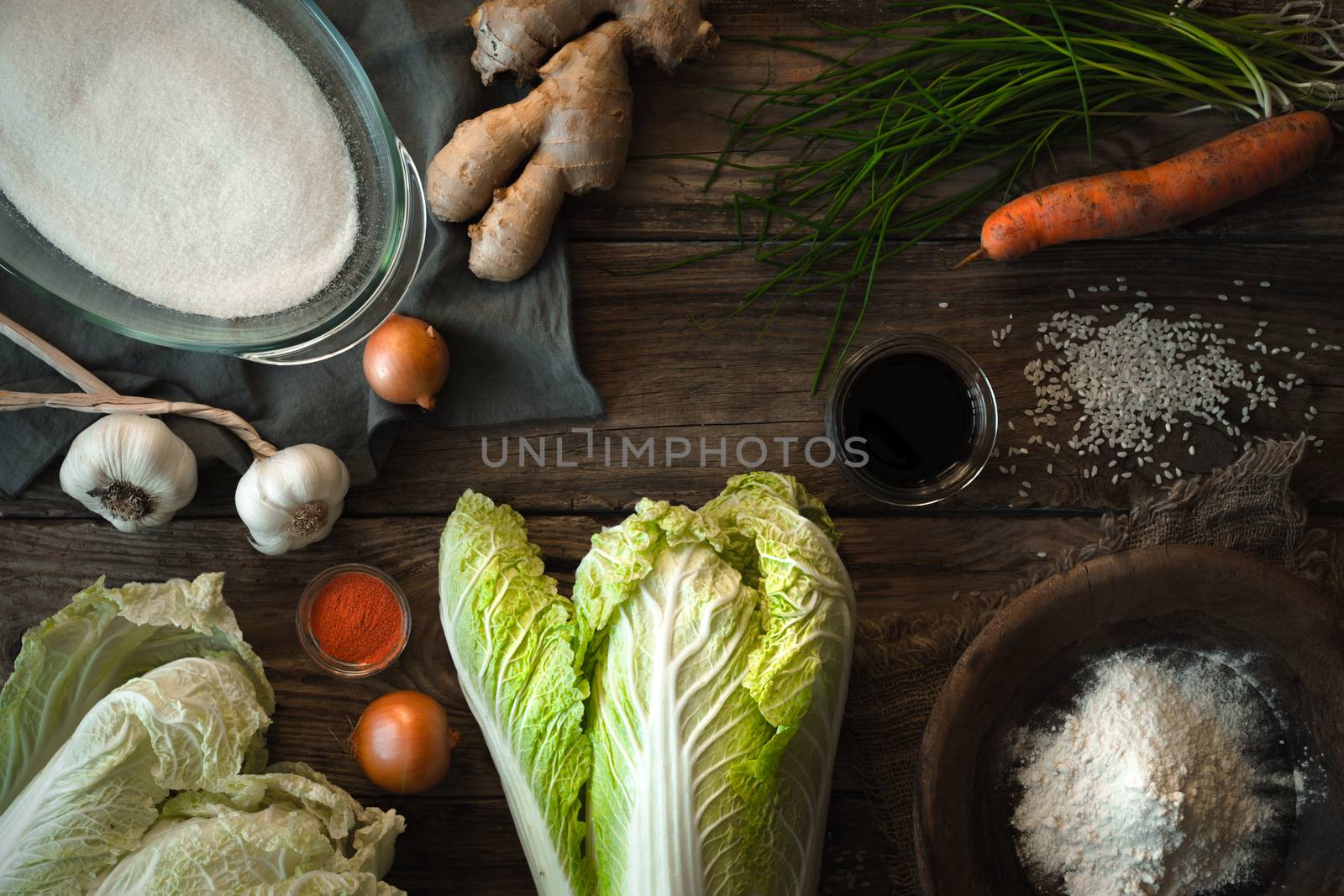 Chinese cabbage kimchi and ingredients on a wooden table by Deniskarpenkov