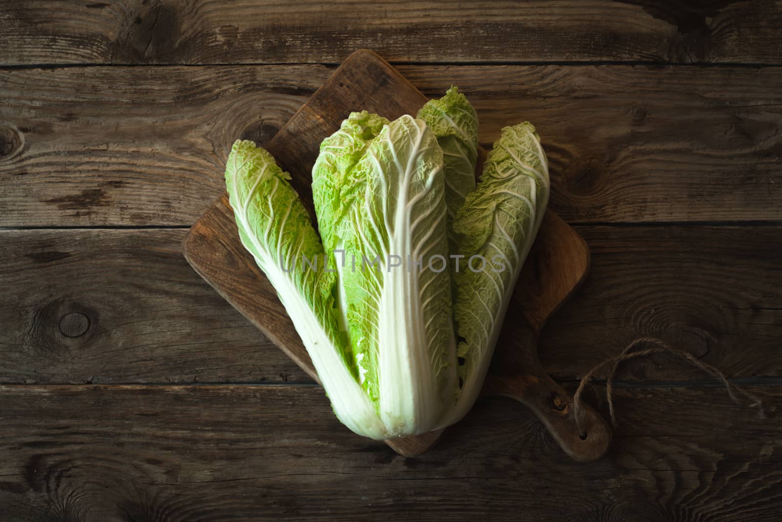 Chinese cabbage on a cutting board on old boards by Deniskarpenkov