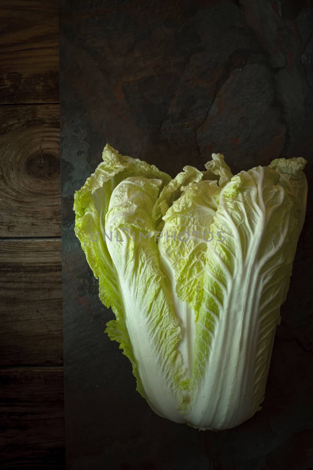 Chinese cabbage on a gray slate on old boards by Deniskarpenkov