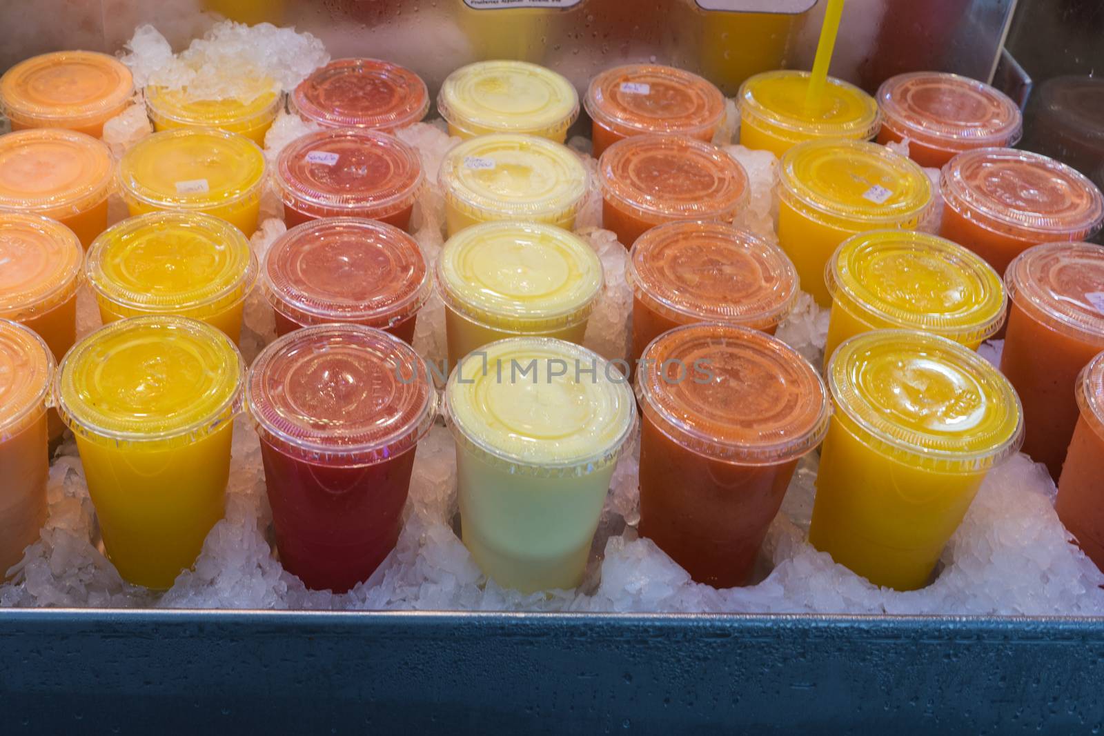 Colorful glasses of fresh fruit juice displayed at the Mercado de La Boqueria in Barcelona. The Mercat de Sant Josep de la Boqueria, often simply referred to as La Boqueria is a large public market in the Ciutat Vella district of Barcelona, Catalonia, Spain and one of the city's foremost tourist landmarks. The market has a very diverse selection of goods.