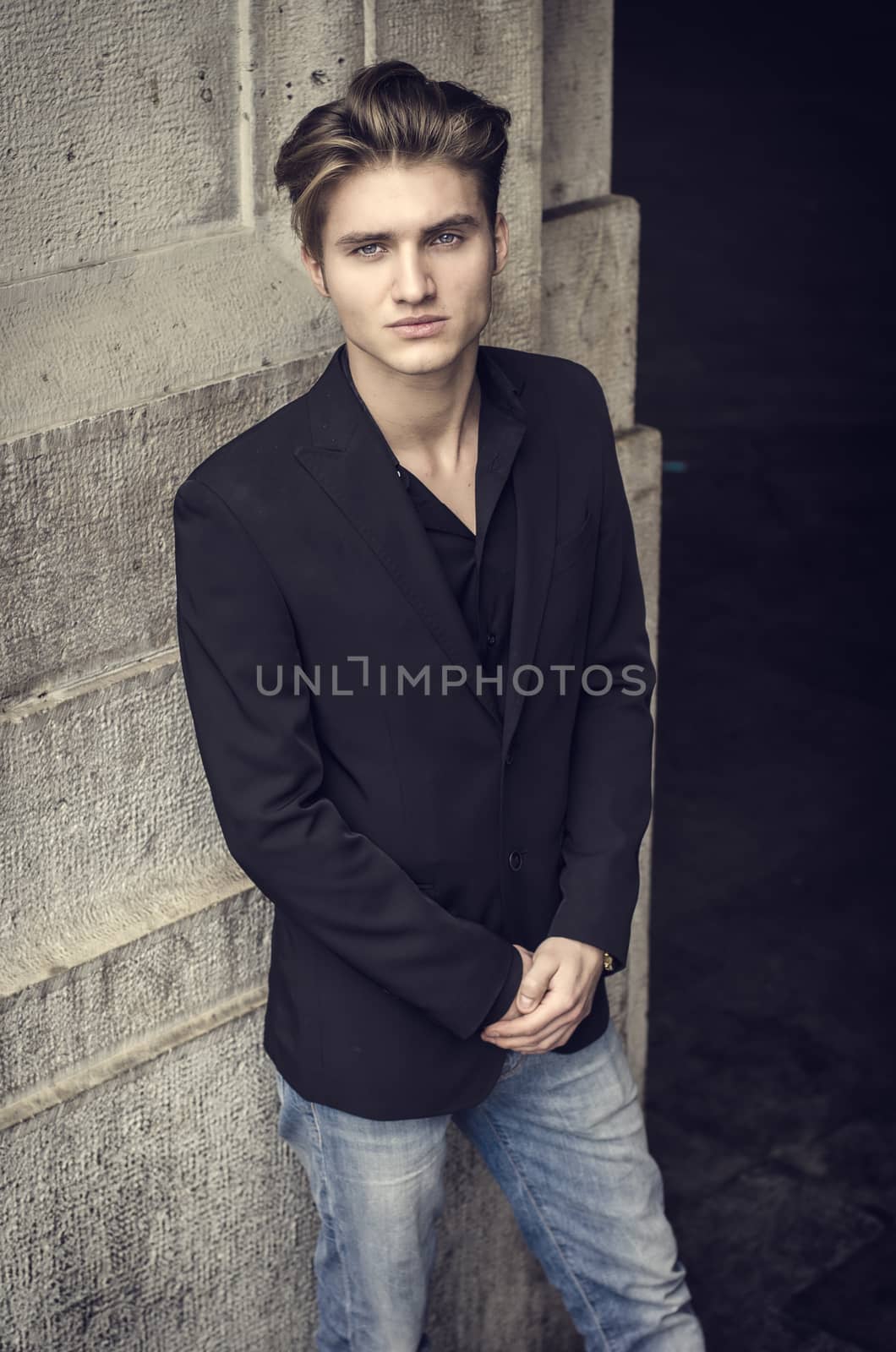 Attractive blue eyed, blond young man leaning against white wall by artofphoto