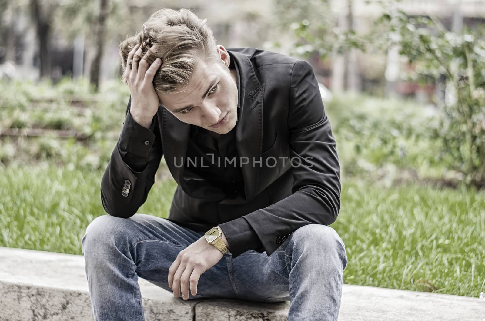 Depressed Young White Man Sitting at Street Side by artofphoto