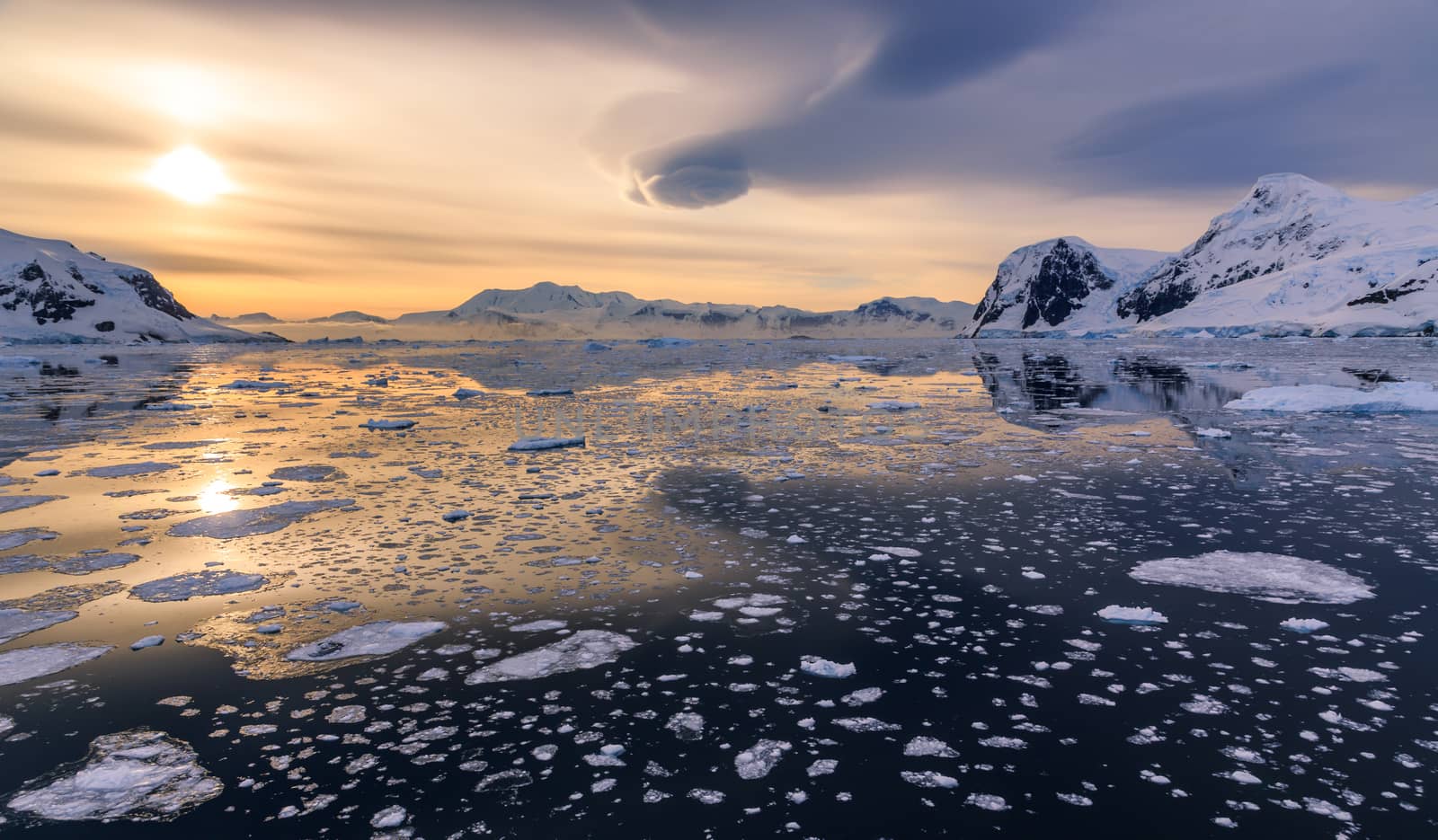 Icebergs and sunset reflecting in water at Lemaire Strait, Antarctica