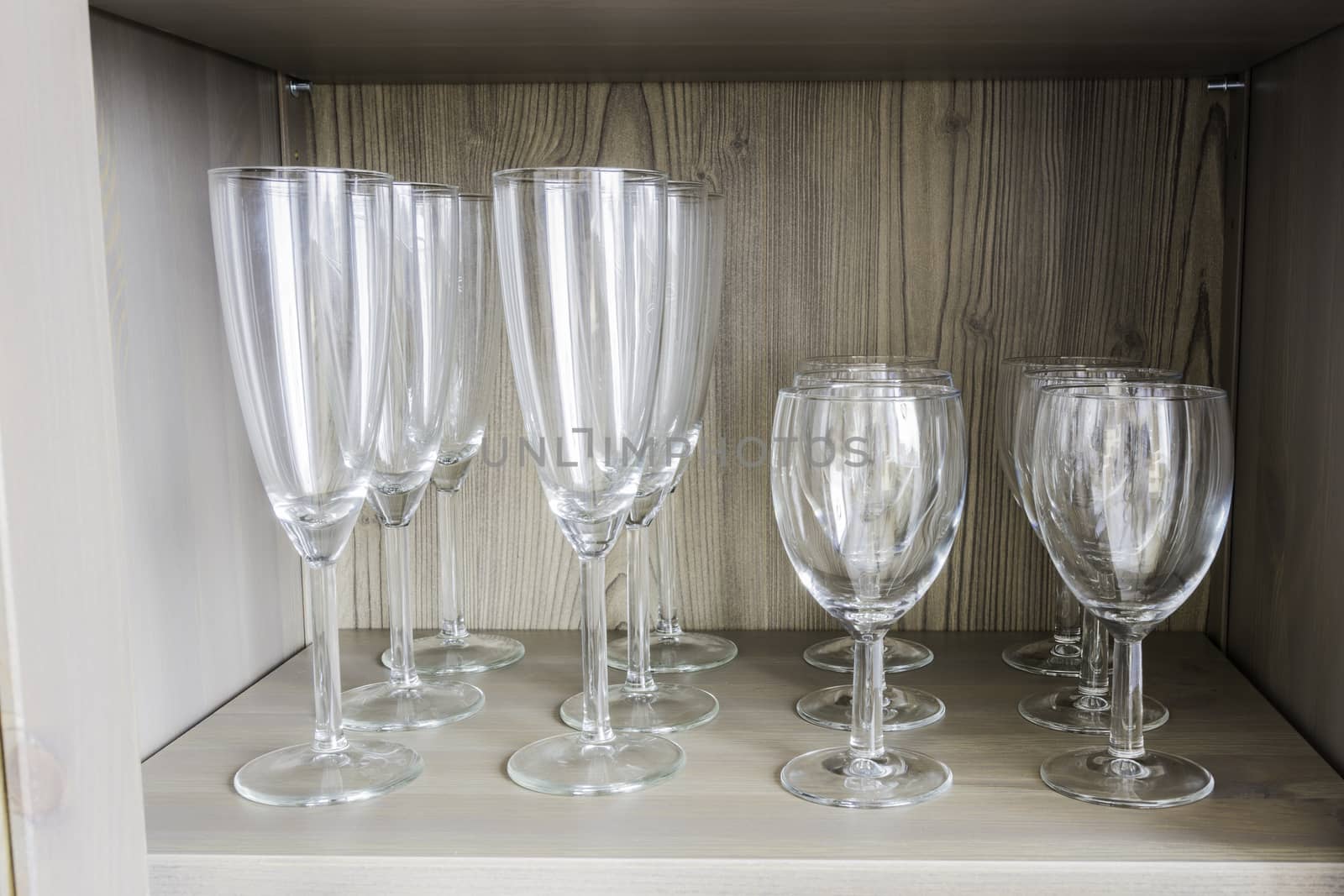 Collection of wine glasses on a wooden shelf