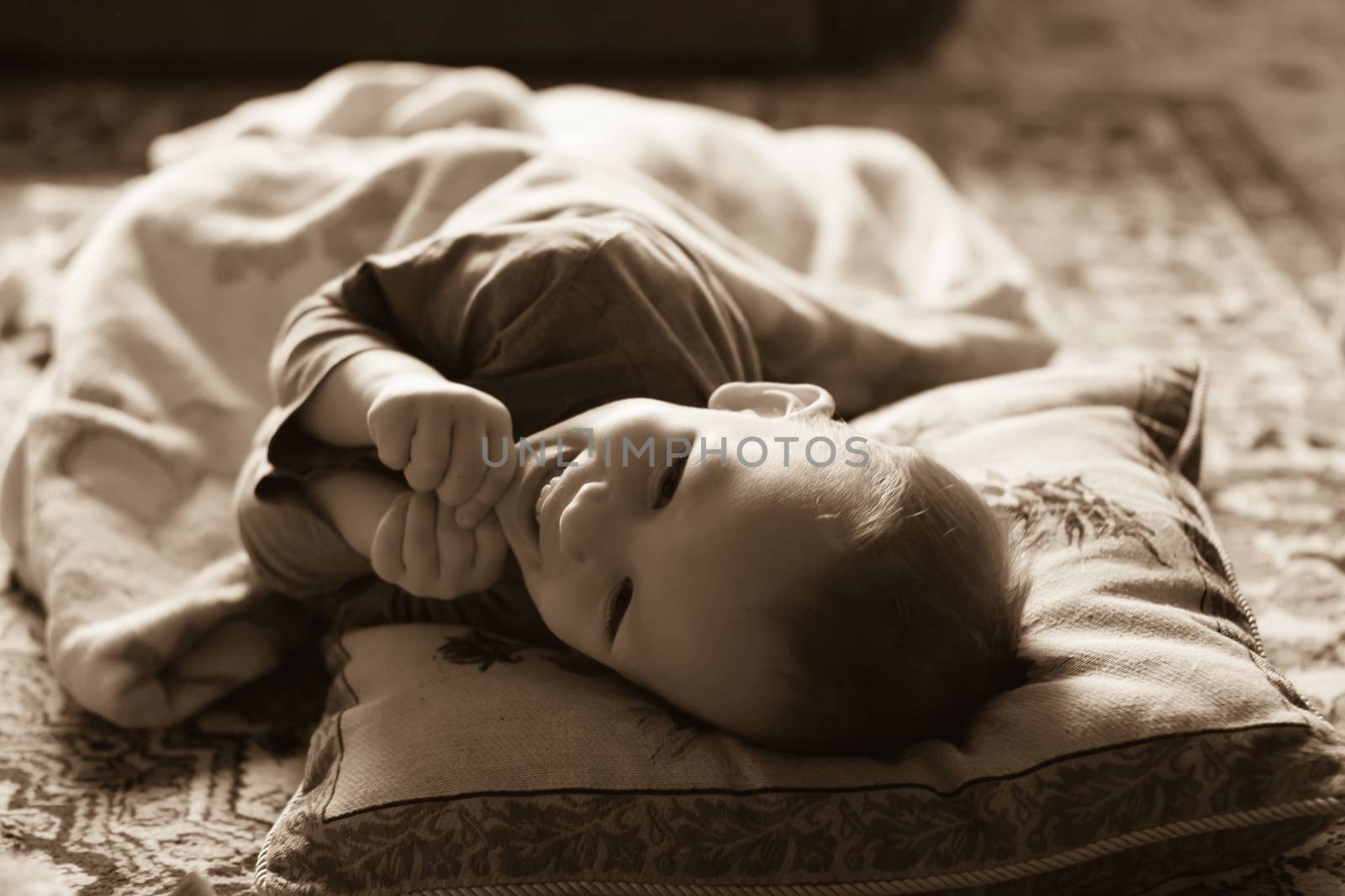 Happy laughing baby lying on a bed by natazhekova